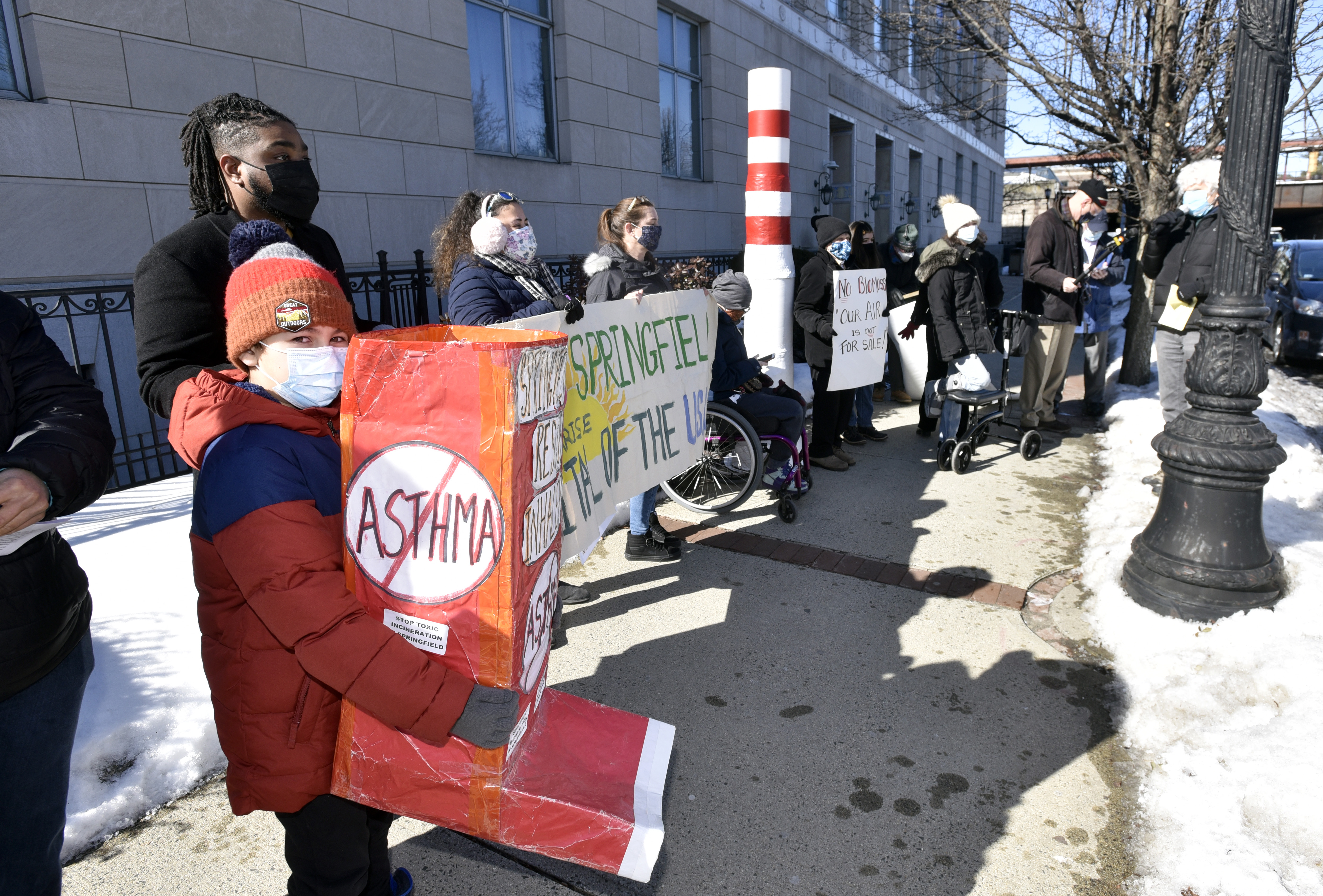 Demonstrators stand outside the Western Massachusetts office of Governor Charlie Baker in Springfield to demand an end to the long proposed biomass energy plant in East Springfield on Feb. 17, 2021.   (Don Treeger / The Republican)