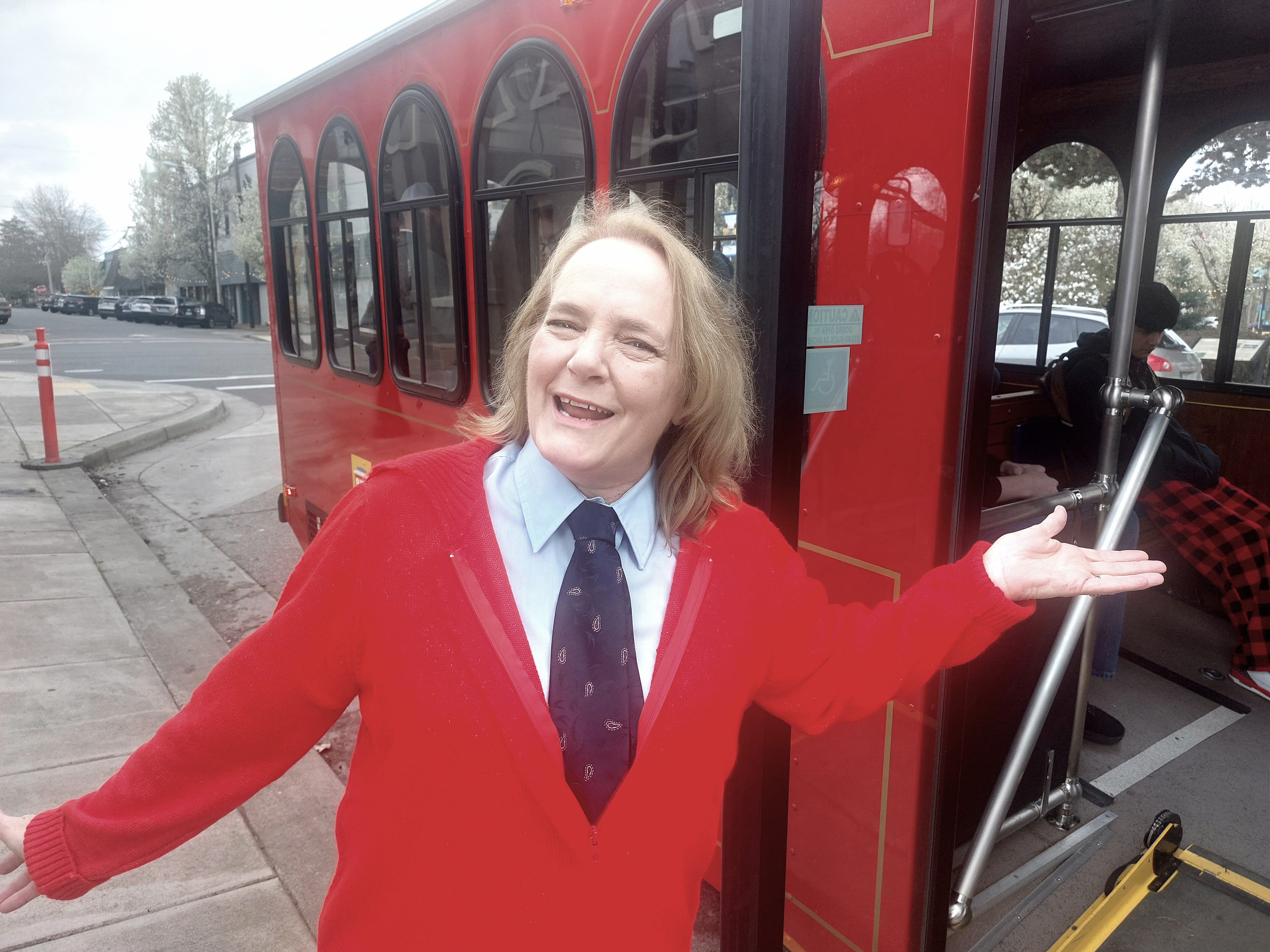 Roxanne Beltz wears a red cardigan sweater and welcomes guests to the red trolley