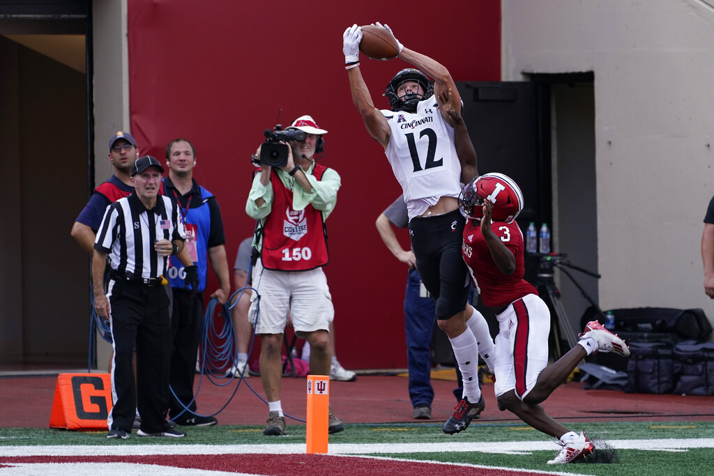 Cincinnati's Alec Pierce (12) stretches for extra yards against East  Carolina during the first …