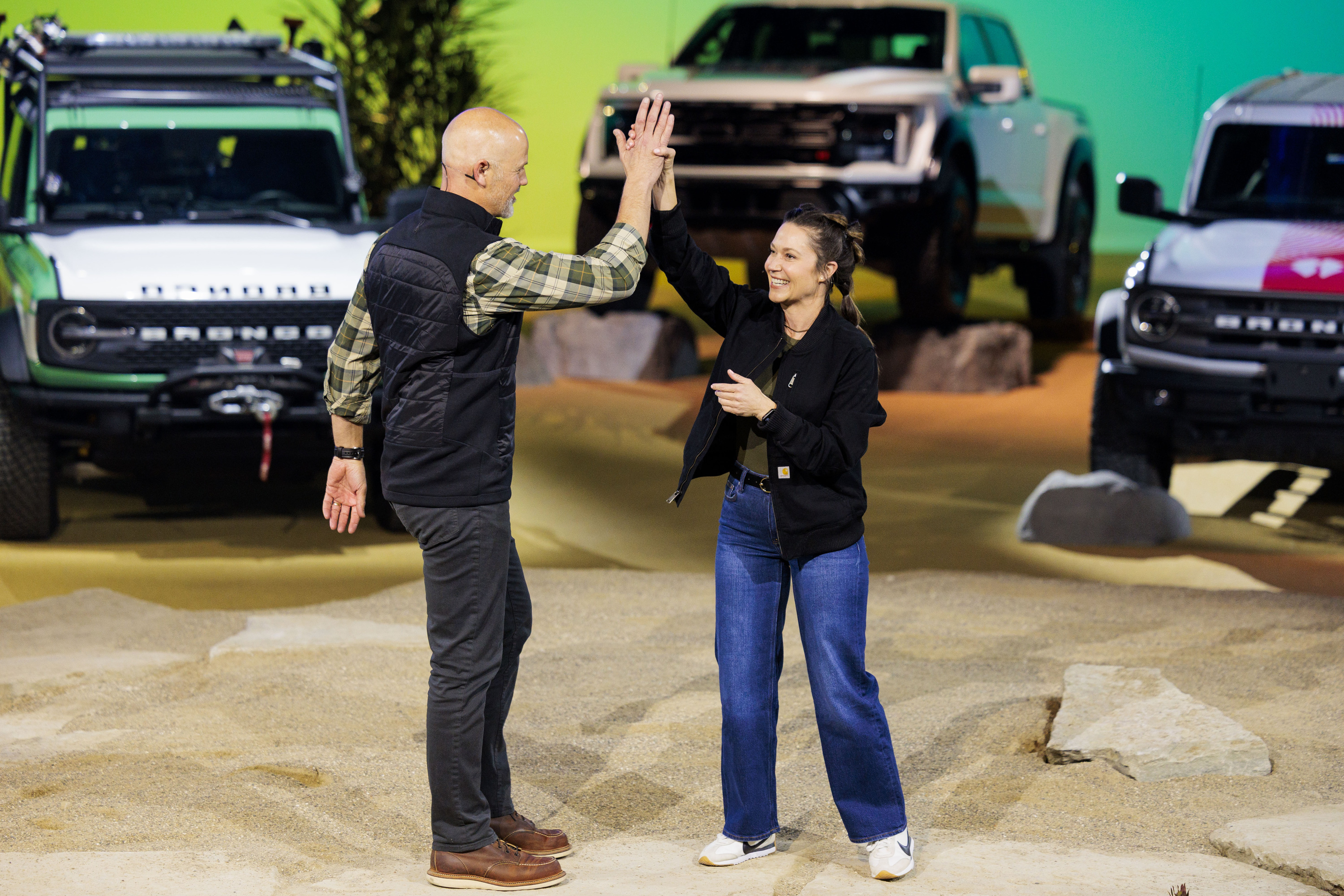Off-road racer Shelby Hall high-fives Jamie Groves, the Bronco Family Engineering Manager for Ford, during a Ford Motor Company event ahead of the Detroit Auto Show at Huntinton Place in Detroit on Tuesday, Jan. 13 2026.