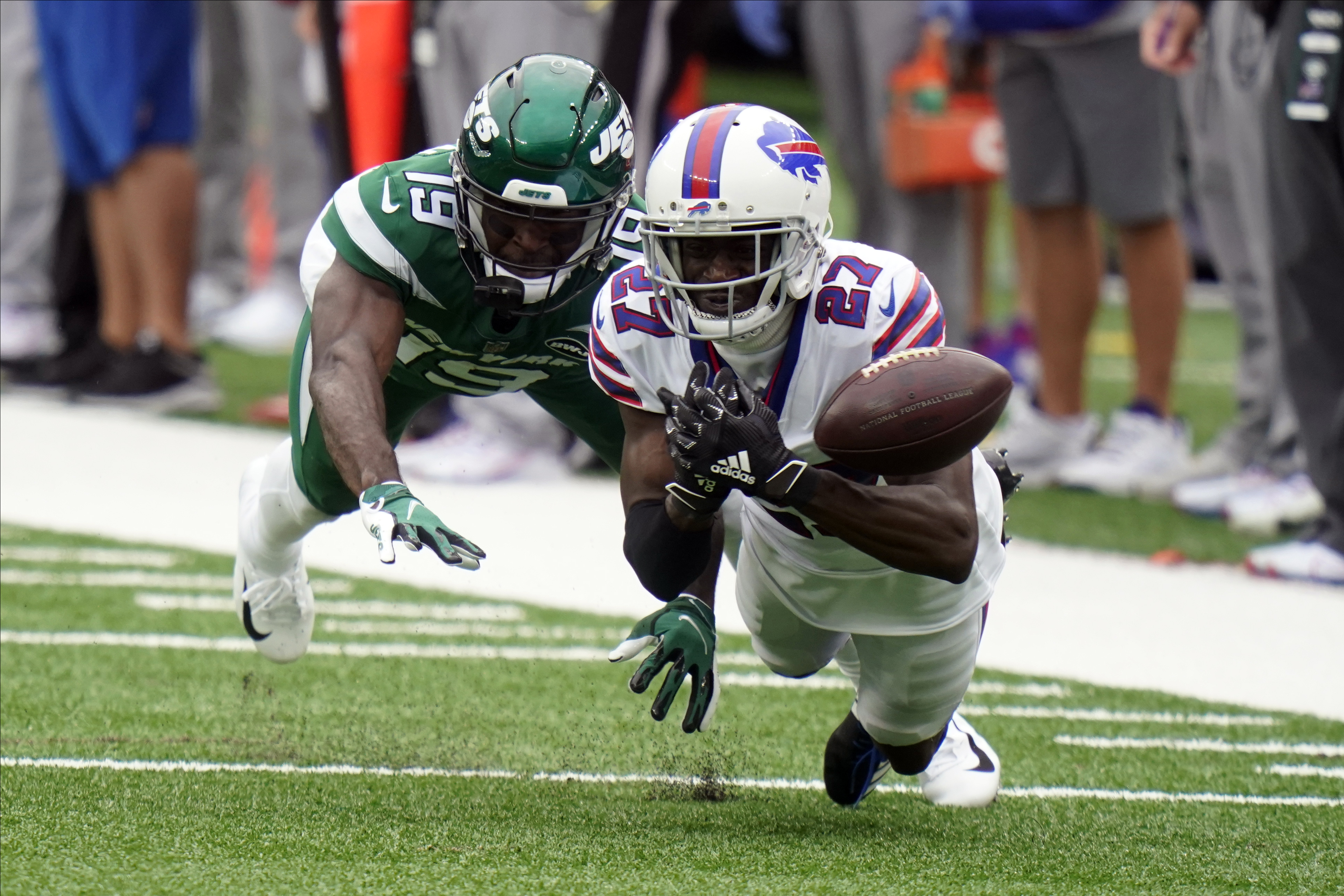 New York Jets' Blessuan Austin, bottom, breaks up a pass intended