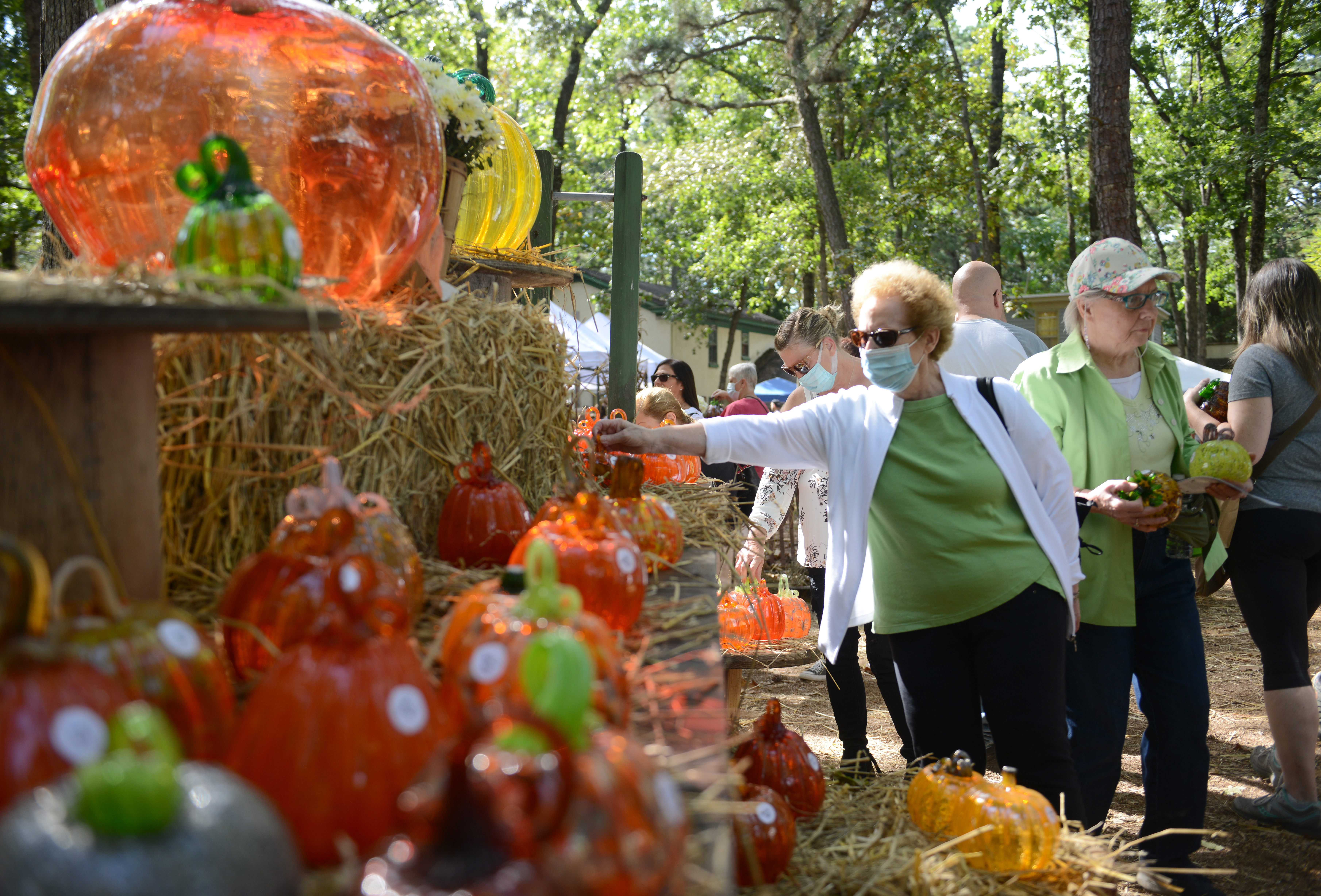 Customers browse the glass pumpkin patch during the 22nd annual Festival of Fine Craft at Wheaton Arts in Millville, Saturday, Oct. 2, 2021.