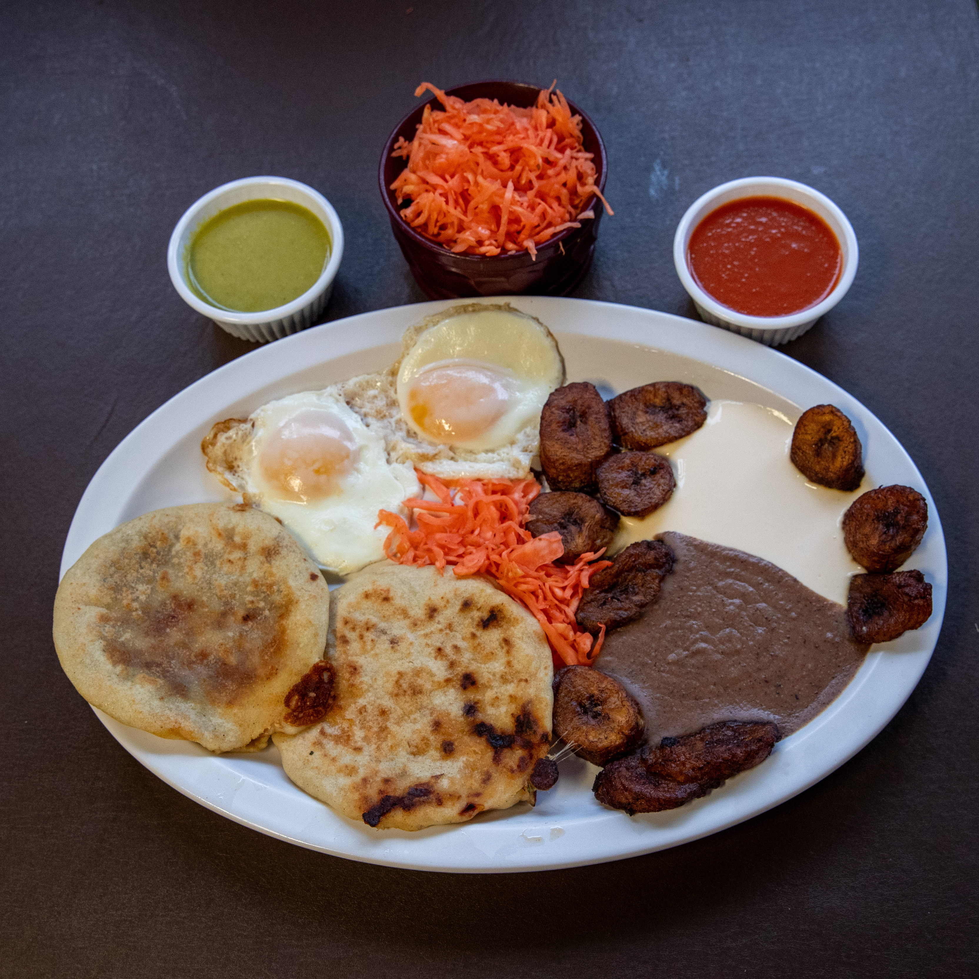 Super Special - two over easy eggs, two pupusas, Salvadorian cream, fried beans, curtido (lightly fermented cabbage relish), plantains and salsa for $18.99 at Pupuseria El Salvador in Wyoming on Thursday, Oct. 19, 2023. (Cory Morse | MLive.com)
