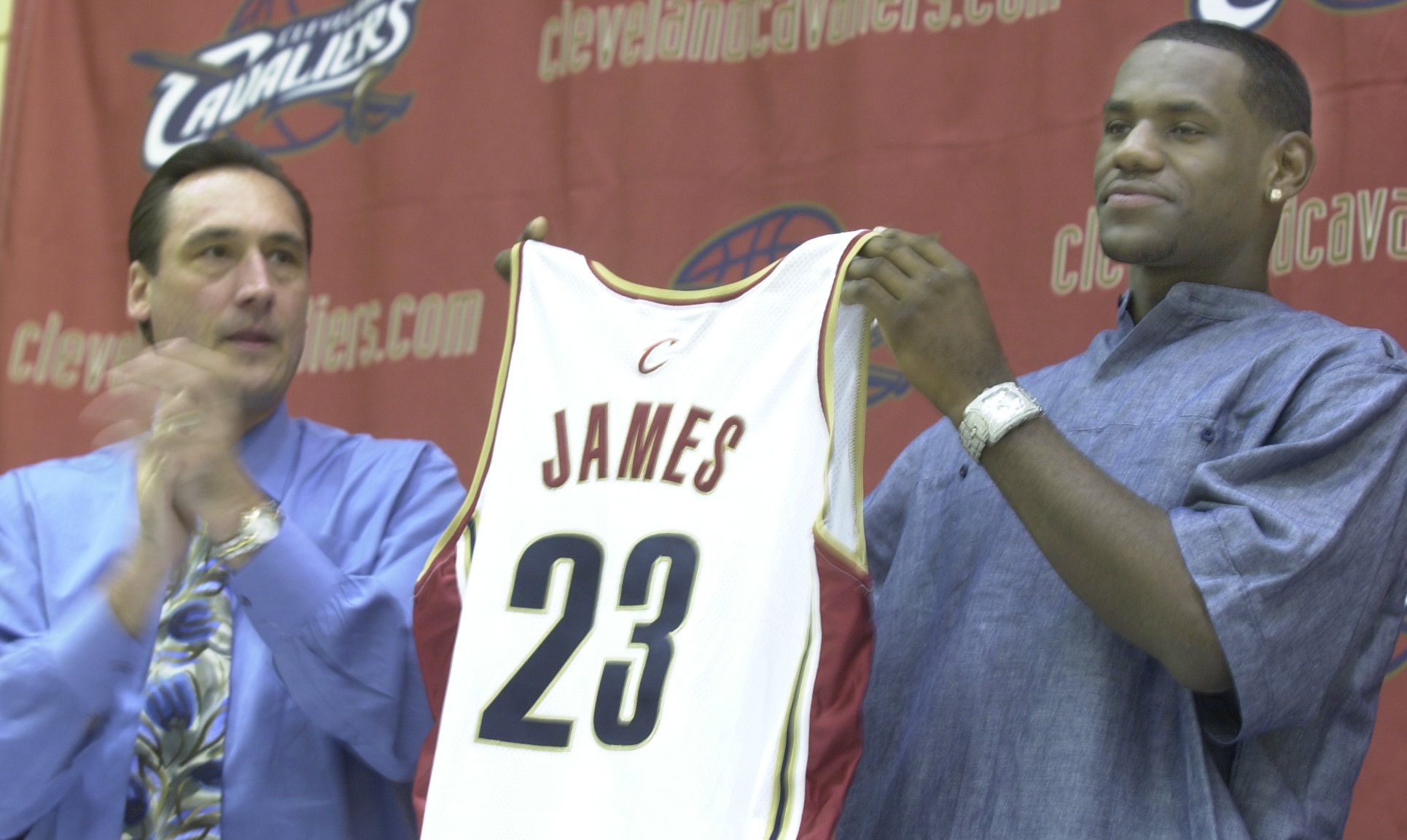 General Manager Jim Paxson, left, gives LeBron James his jersey at his first news conference Friday after being selected first overall in the NBA Draft. (C.H.Pete Copeland/ The Plain Dealer)