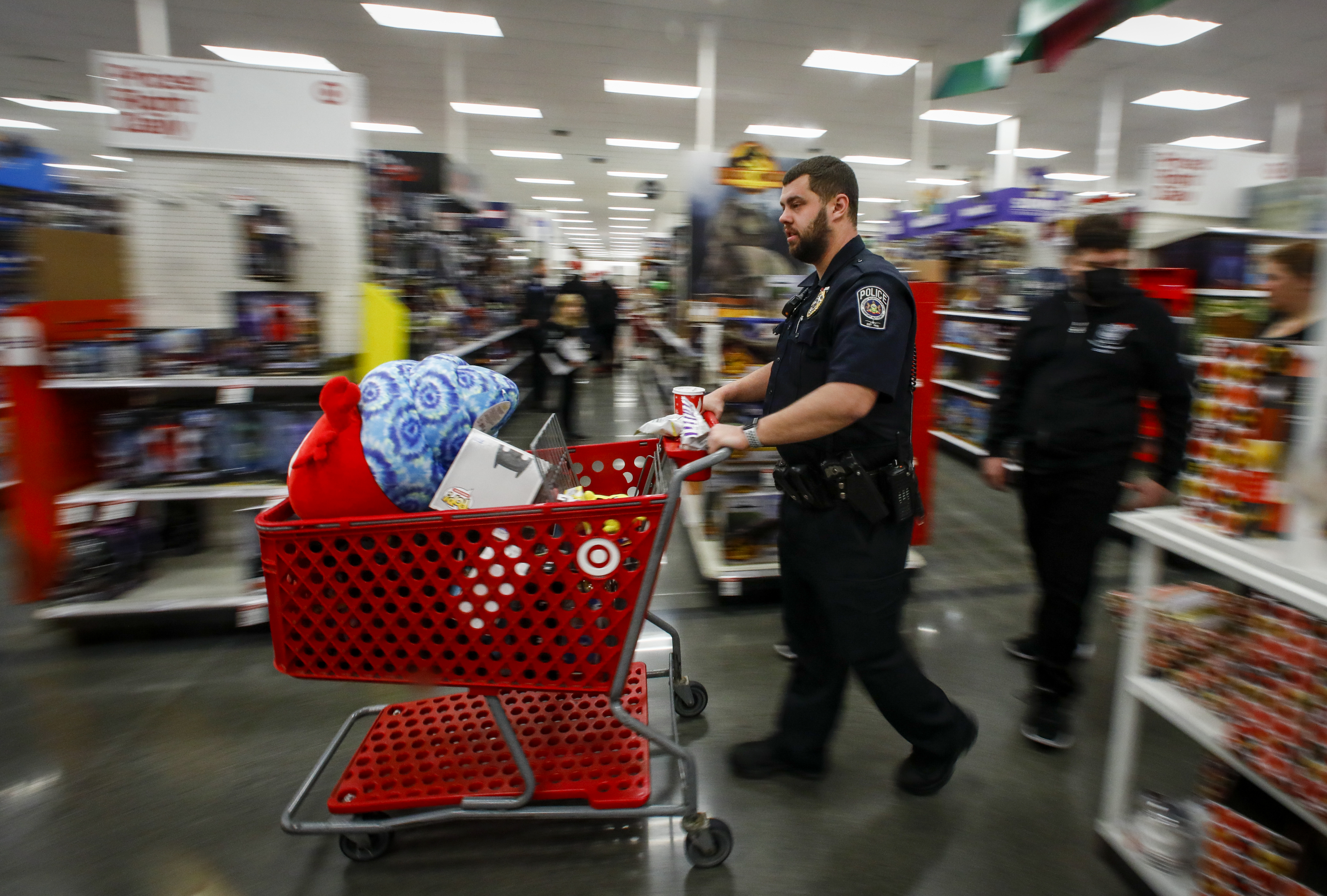 Officer Troy Leonard with Lehigh-Northampton Airport Authority Police Department pushes a cart full of items during a holiday shopping spree Saturday, Dec. 3, 2022, at Target in Hanover Township. The Lehigh-Northampton Airport Authority Police Department helped 22 children and their families from the Catasauqua Area School District on the shopping spree. 