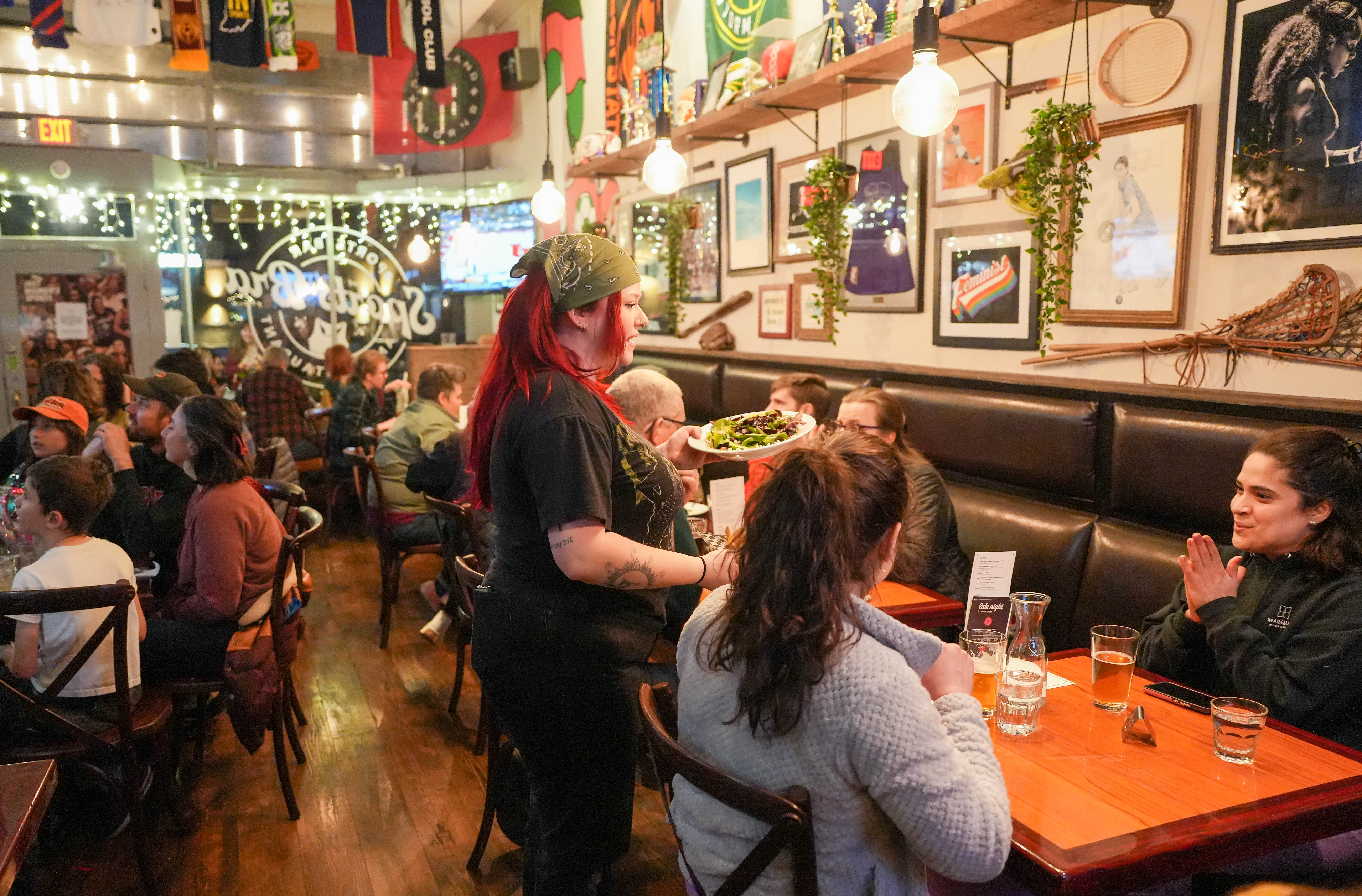 Server delivers food in crowded dining room