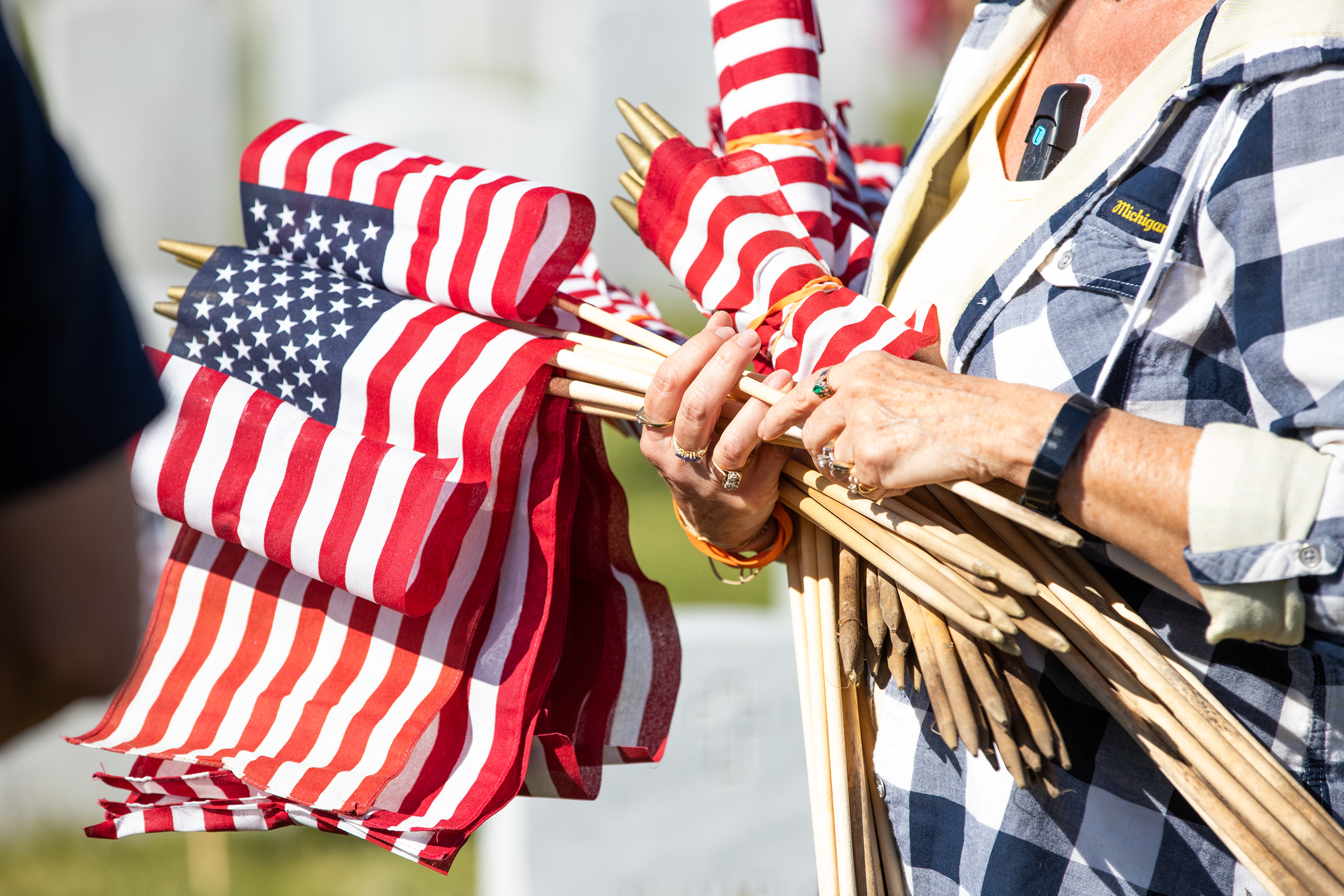 Volunteers place flags on graves ahead of memorial day at the Great