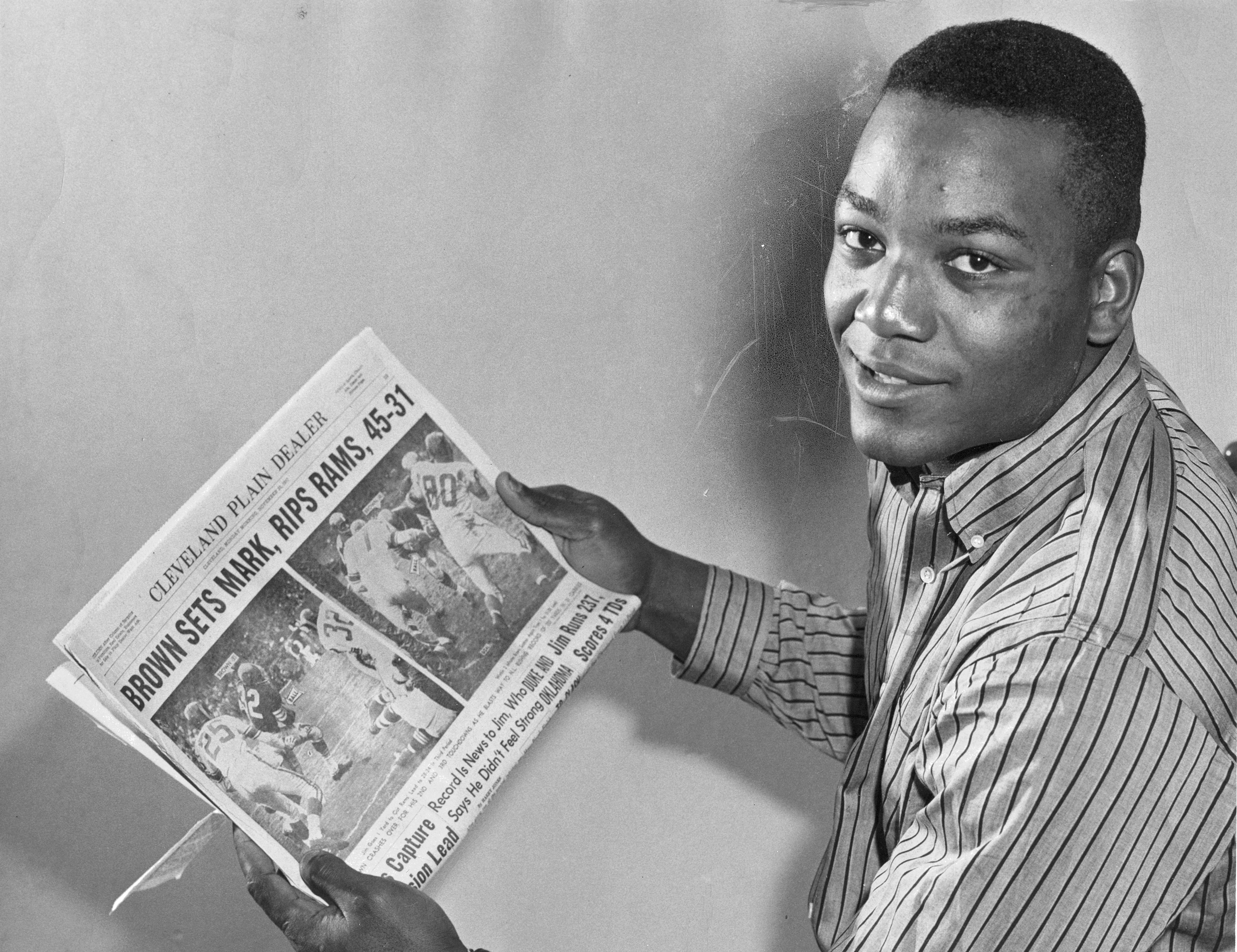 PDHST PLAIN DEALER HISTORICAL PHOTOGRAPH COLLECTION: CLEVELAND BROWNS

Jim Brown holds up a copy of the Cleveland Plain Dealer from November 25, 1957.



NOTES FROM GAME STORY:

Brown Sets Mark , Rips Rams, 45-31 

Jim Runs 237, Scores 4 TDs 

November 24, 1957

Browns 45, Los Angeles Rams 31 

Cleveland Municipal Stadium 



Jim Brown took personal charge of the Browns' offense yesterday at the Stadium. 



Before an amazed crowd of 65,407, largest turnout here since 1953, the rookie fullback from Syracuse gave a tremendous exhibition of running. 



Brown scored four touchdowns, one on a 69-yard jaunt, and accumulated 237 yards for a new National League record as the surprising Browns smashed the Los Angeles Rams, 45-31, to remain on top in the Eastern Division.