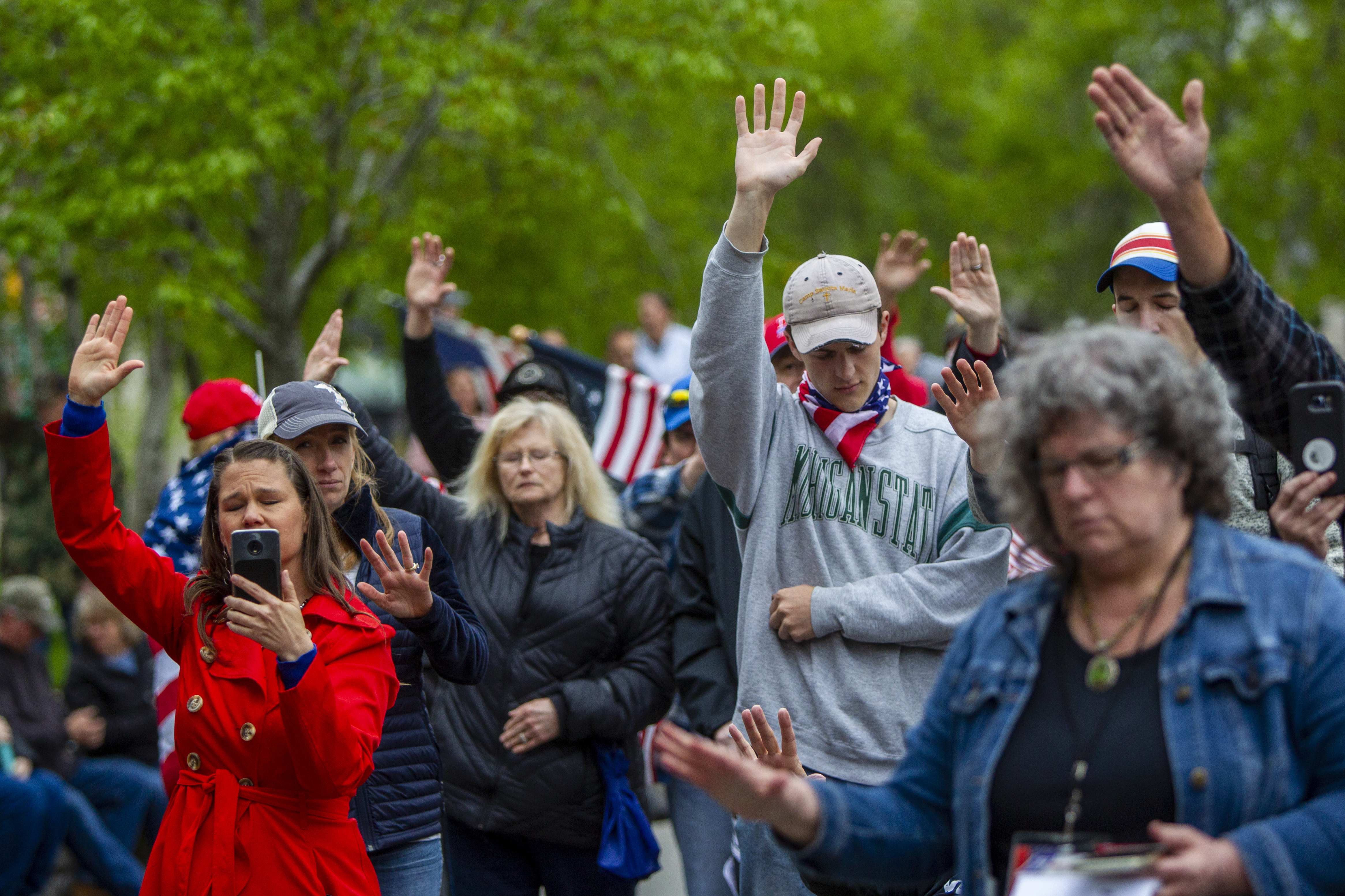 A crowd prays for law enforcement during the "American Patriot Rally-Sheriffs speak out" event at Rosa Parks Circle in downtown Grand Rapids on Monday, May 18, 2020. The crowd is protesting against Gov. Gretchen Whitmer's stay-at-home order. (Cory Morse | MLive.com)