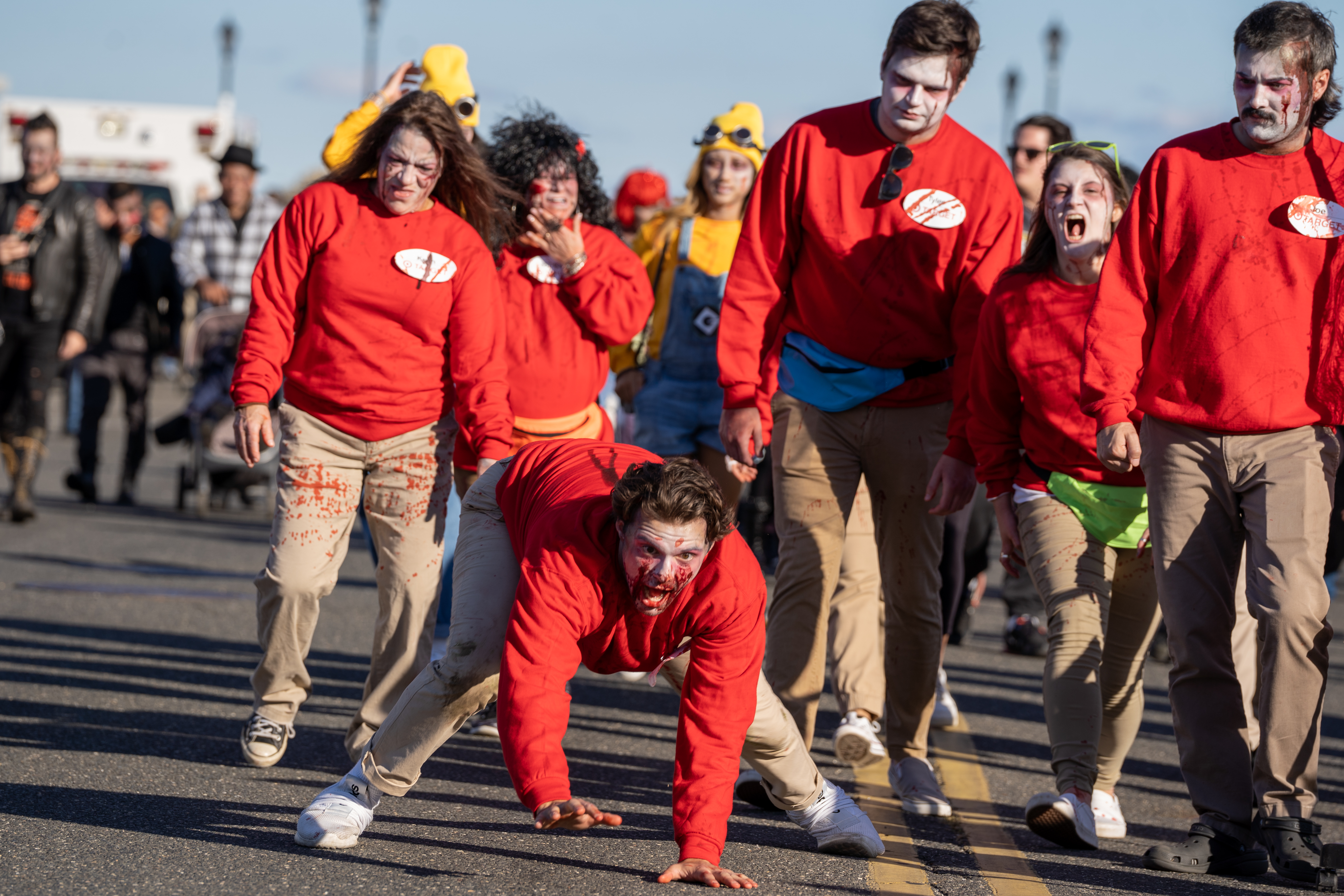 Mike Wagner, walking on all fours, leads a pack of zombie Target employees down the street during the 14th Asbury Park Zombie Walk in Asbury Park on Saturday, October 8, 2022. The zombie walk held its first themed year with the theme being 80's and 90's punk and metal.