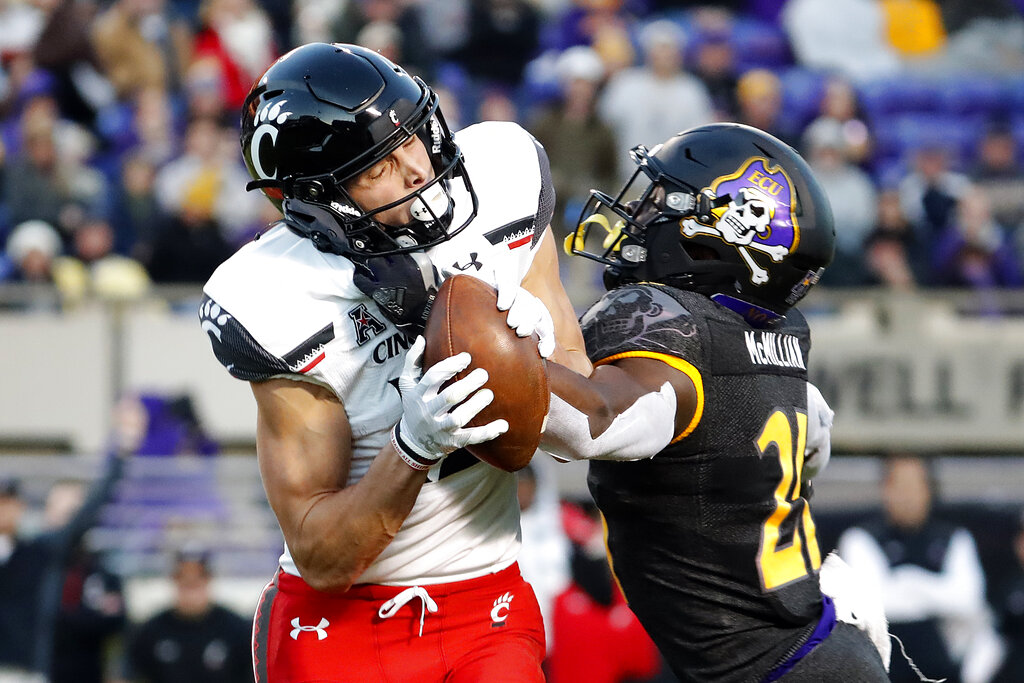 Cincinnati's Alec Pierce (12) stretches for extra yards against East  Carolina during the first …