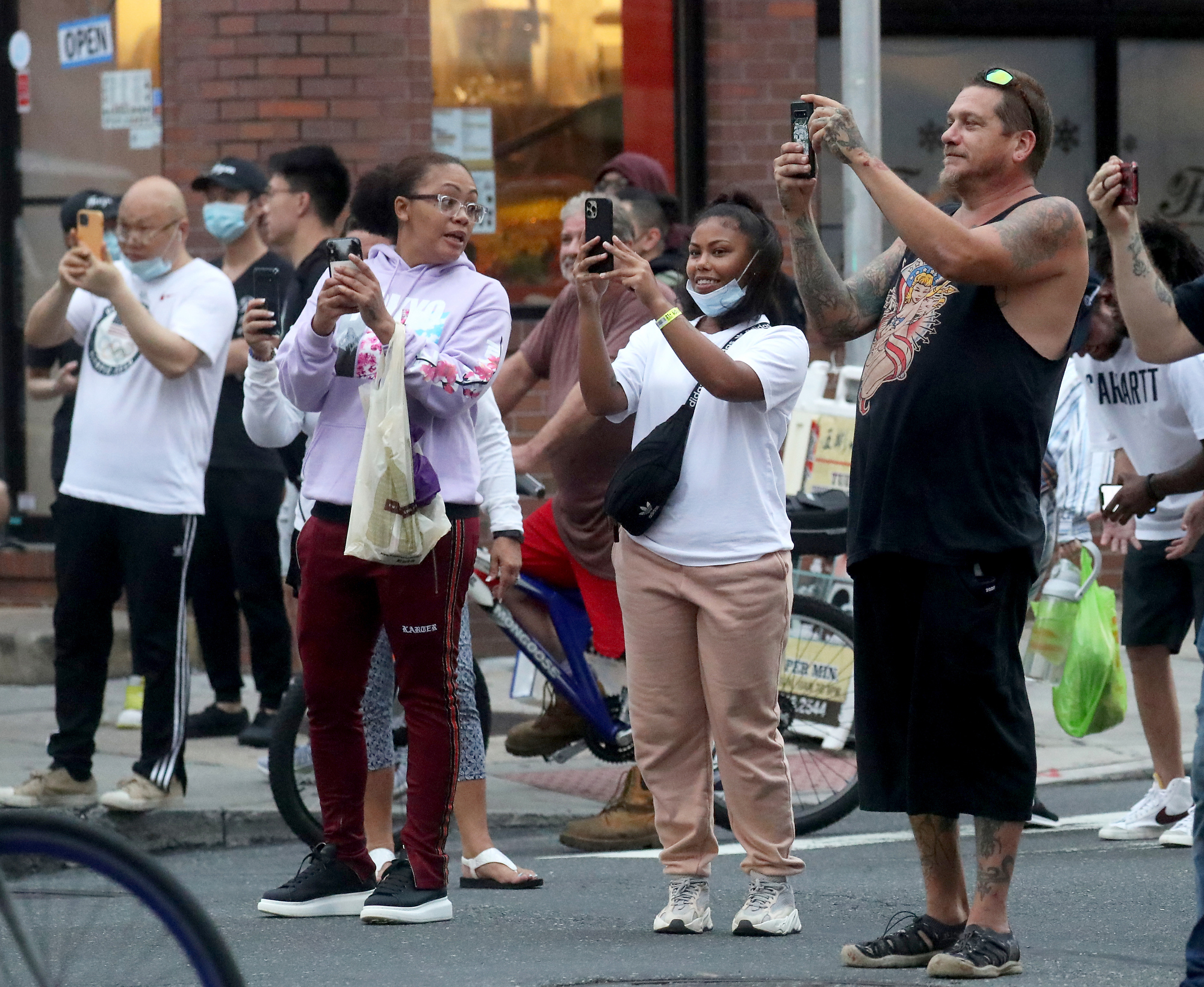 People watch and record as participants in the Philly Naked Bike Ride ride along Arch Street in Philadelphia, Saturday, Aug. 28, 2021.