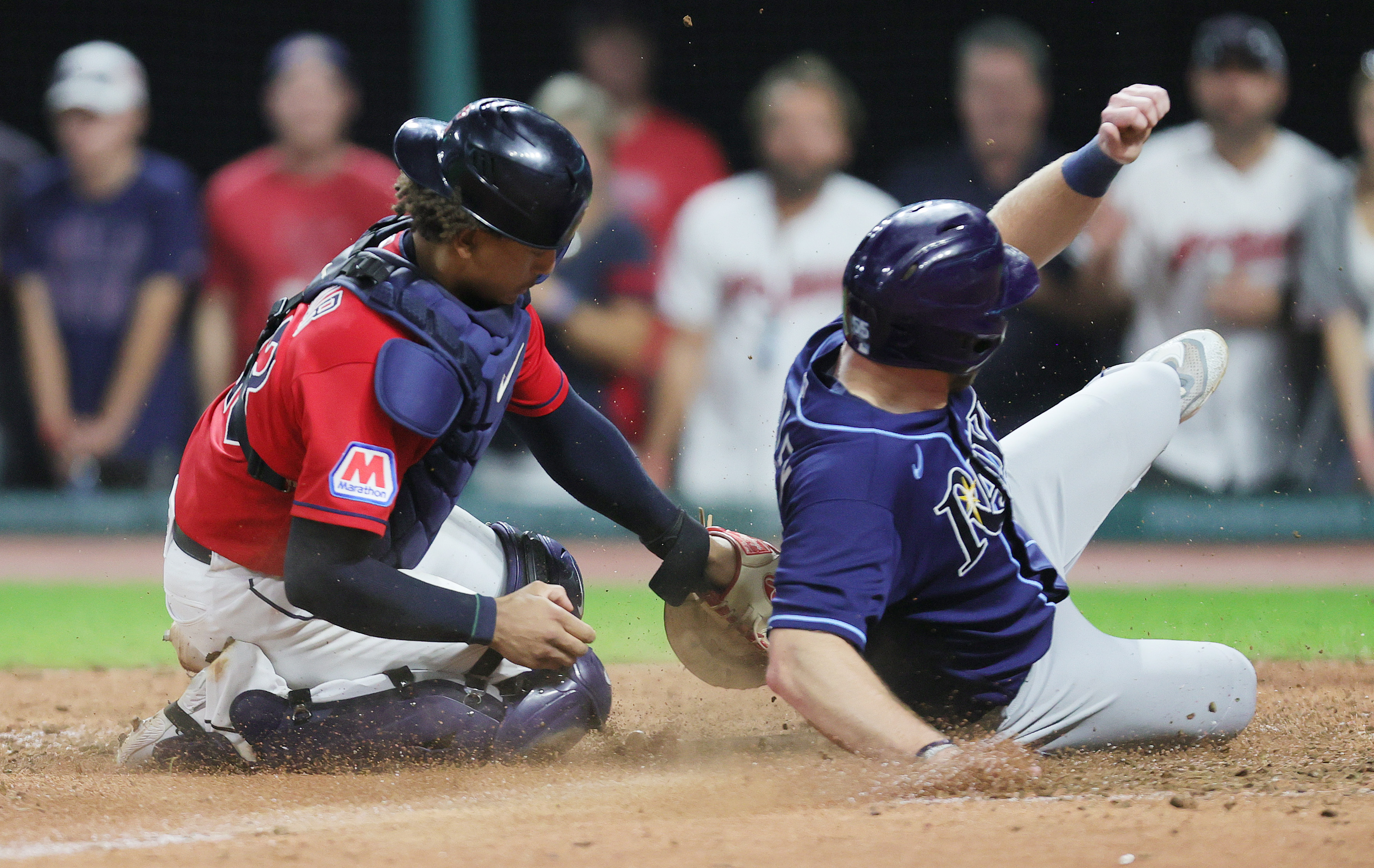 Cleveland Guardians catcher Bo Naylor tags out Tampa Bay Rays first baseman Luke Raley at home plate