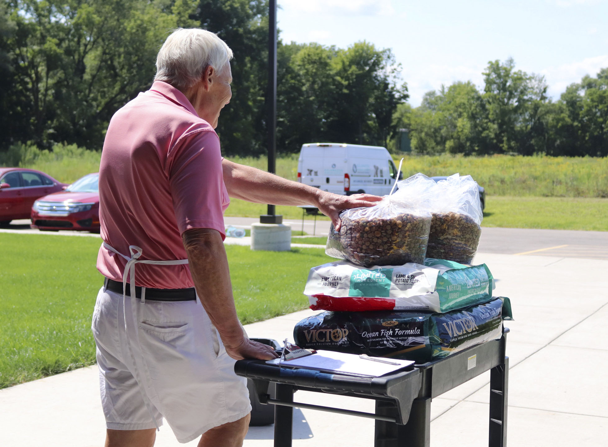John Nowak take pet food out to the drive through on Tuesday, Aug. 23, 2022, at Charles and Lynn Zhang Animal Care & Resource Center in Kalamazoo. Nowak is a volunteer for the Kalamazoo Humane Society.