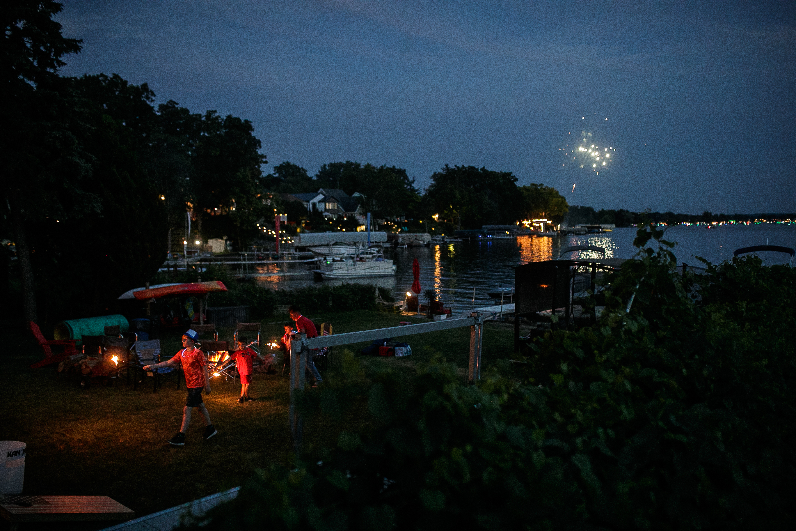 A family plays with sparklers in the their backyard before the annual Lake Fenton Fireworks on the water in front of the Township hall on Saturday, June 2, 2022 in Fenton Township. (Jenifer Veloso | MLive.com)

