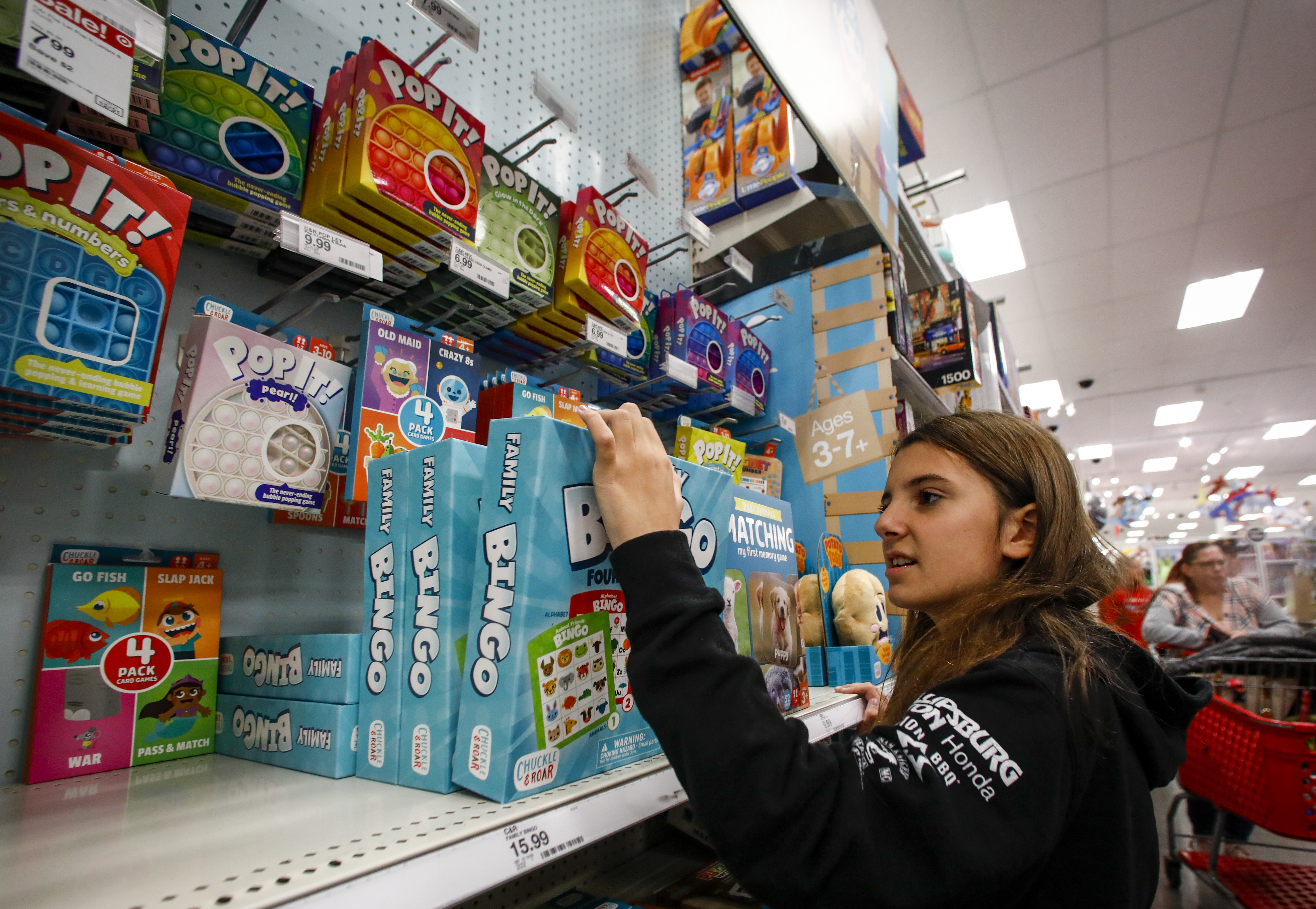 Kayleigh Wagner, 10, selects a board game to buy during a holiday shopping spree. She was among 22 children and their families from the Catasauqua Area School District who were accompanied by Lehigh-Northampton Airport Authority Police Department during the shopping spree Saturday, Dec. 3, 2022, at Target in Hanover Township, Lehigh County. 