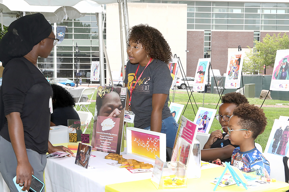 Shennell Ford talked about her program Heart to Heartbeat as her children Jeyce and Jezari Ford-Capdeville look on at Chalk for Change 2022 taking place at Court Square in Springfield on July 16th. (Ed Cohen Photo)