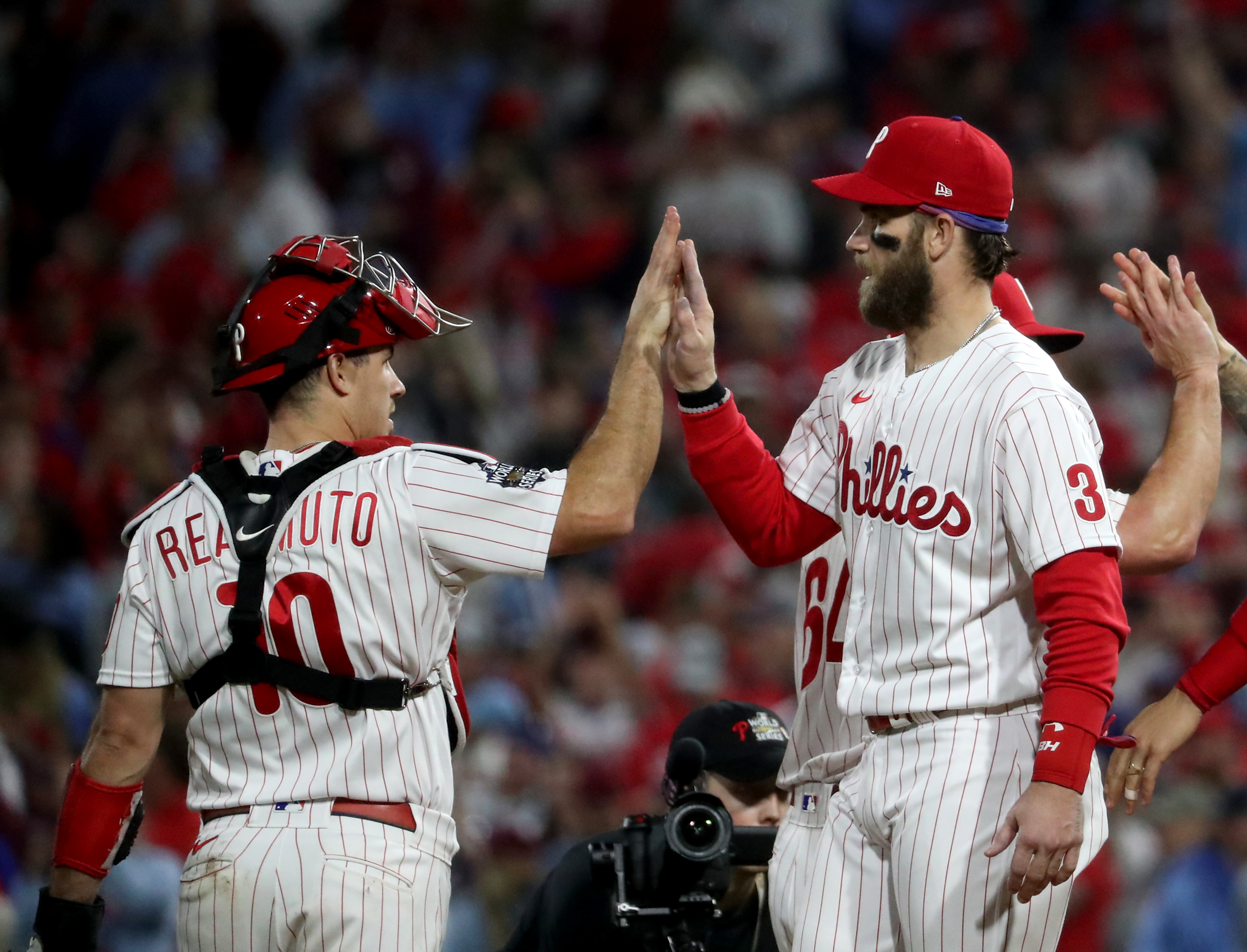 J.T. Realmuto (10) and Bryce Harper (3) of the Philadelphia Phillies celebrate a 7-0 win during World Series Game 3 against the Houston Astros at Citizens Bank Park, Tuesday, Nov. 1, 2022.