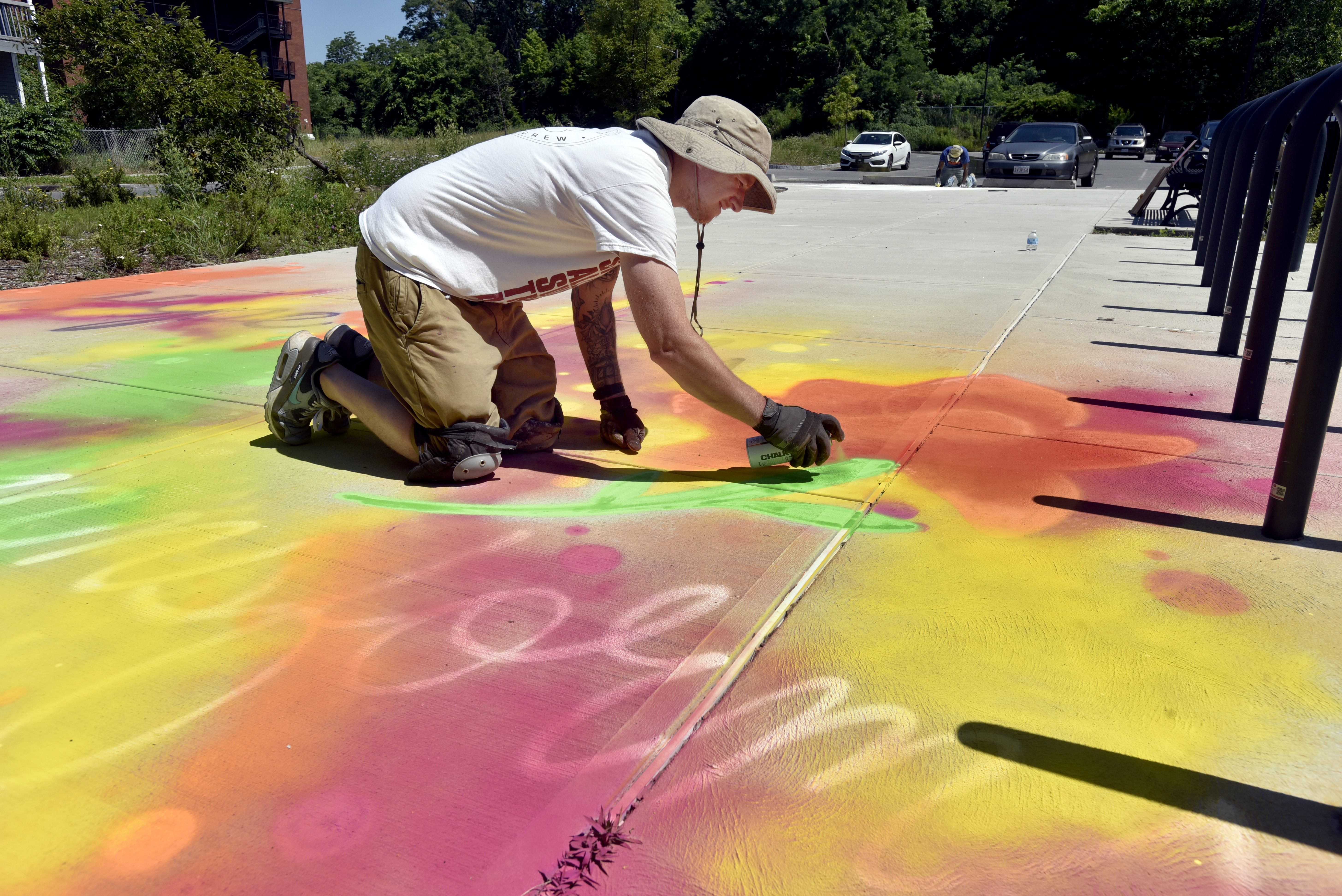 Artist Jeff Nero of Springfield, works on his aerosol chalk creation, "Hope Heals, Trust Transfroms", on the sidewalk at the South End Community Center. This is part of the Trust Transfer Project's "Chalk for Change" initiative that created street art in various locations in downtown Springfield.  (Don Treeger / The Republican)  6/30/2021