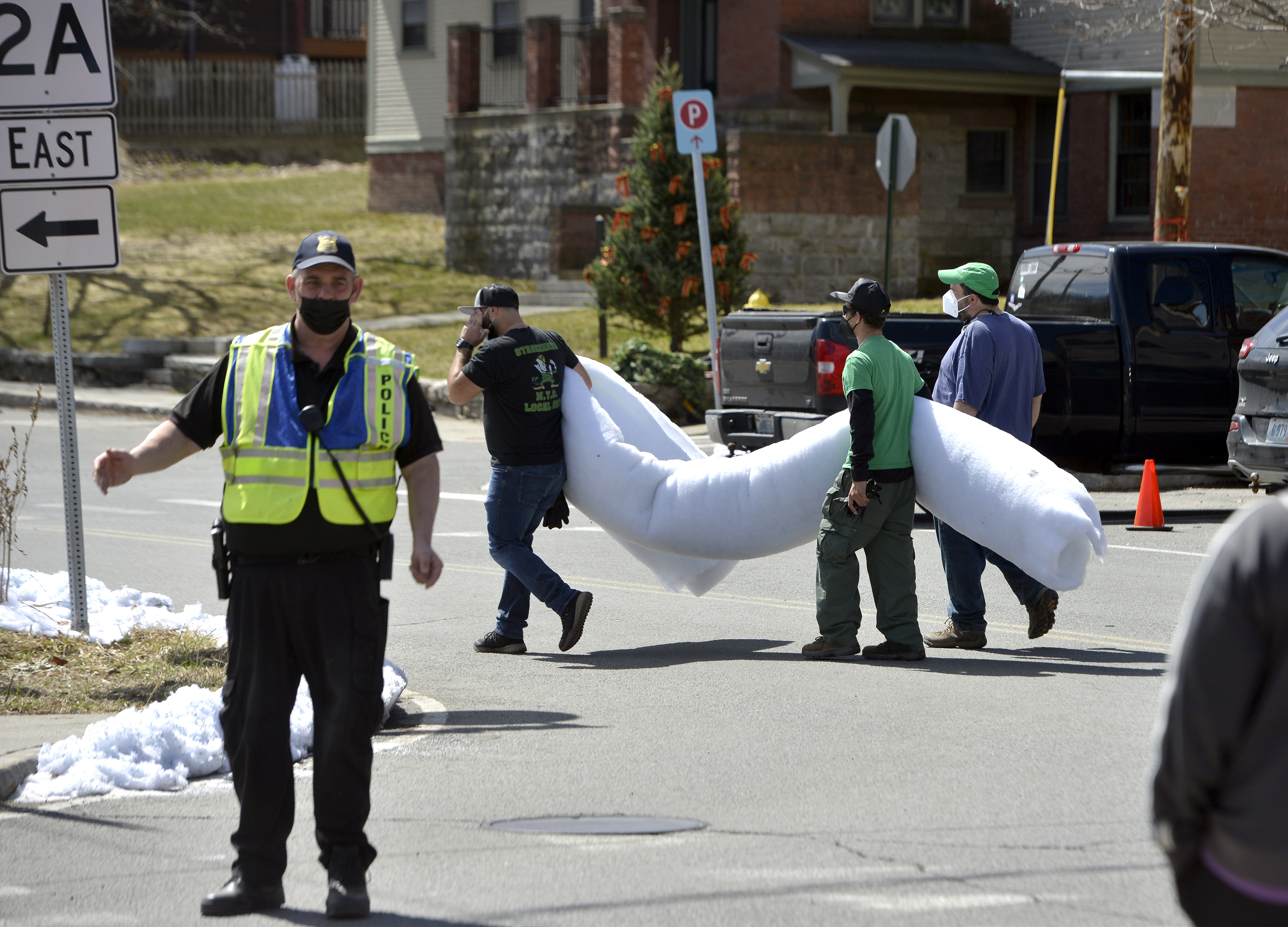 Crew members carry a roll of what will be fake snow across Ashfield Street in Shelburne Falls during the filming of the TV series Dexter, April 7, 2021.   (Don Treeger / The Republican)
