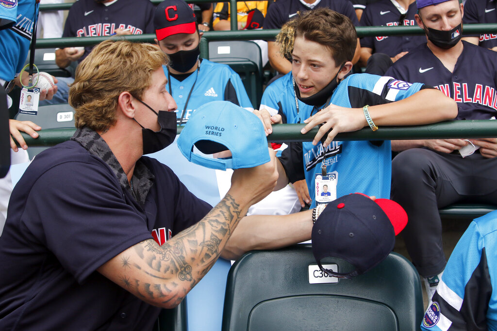 Cleveland Indians' Zach Plesac signs a hat for Nolensville, Tenn.'s Drew  Wagner (19) while they watch the game between Honolulu, Hawaii and  Hastings, Neb. during the a baseball game at the Little