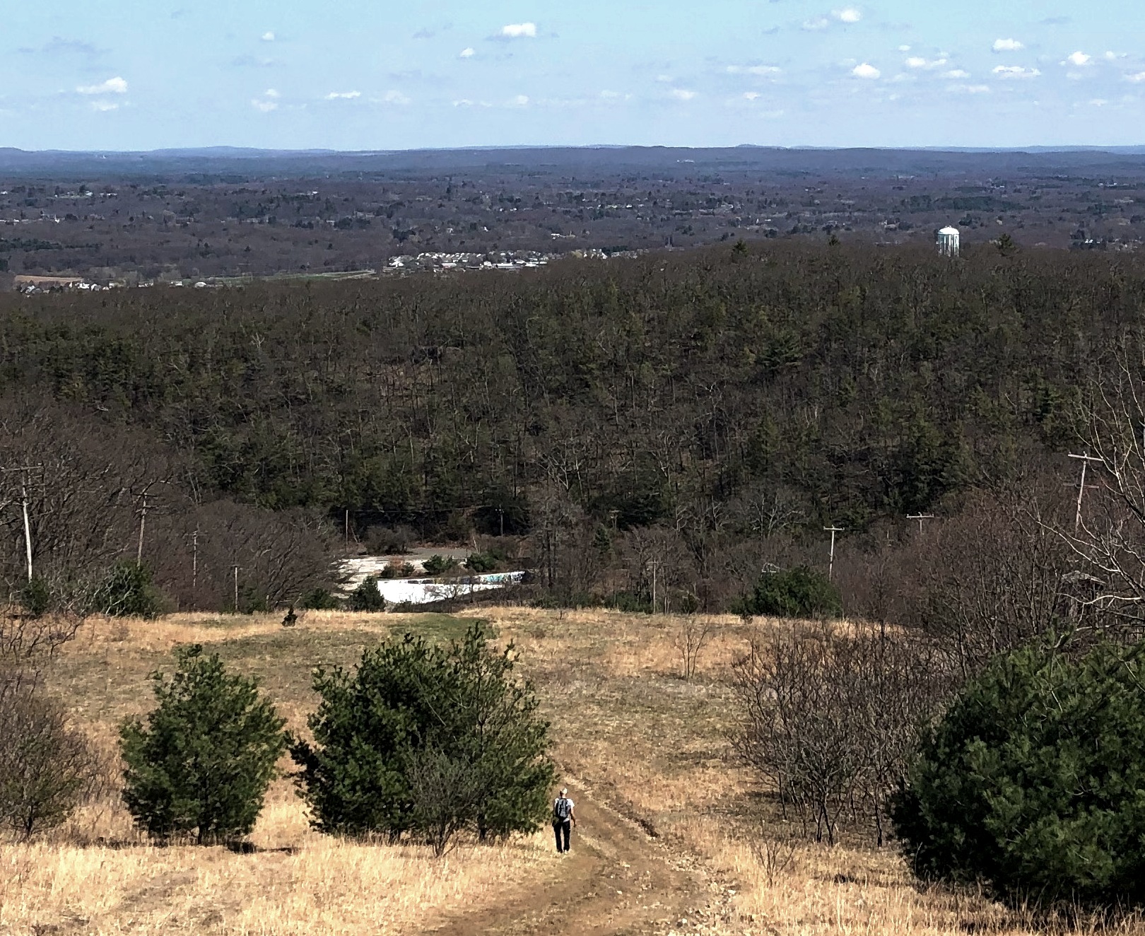 A lone hike walks down the side of Mt. Tom toward the side of the former ski lodge. The state is interested in maintaining Mt. Tom as a resource for nature and outdoor activities.