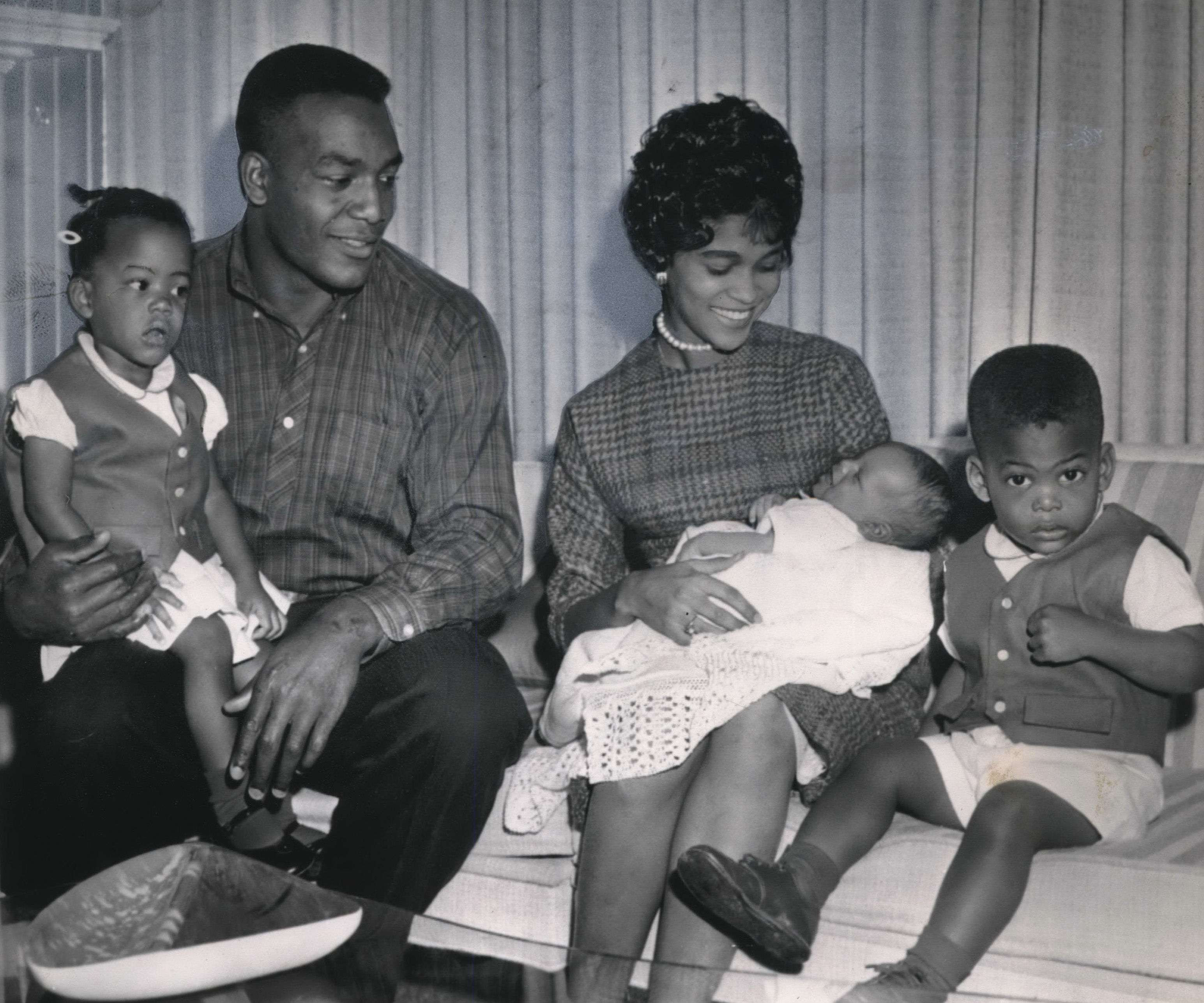 The Browns of Cleveland are not excited over the former Orange grid star's great day against the Philadelphia Eagles.  Jim Brown cruised along for 237 yards gained to tie his old single game NFL mark set in 1957.  Seated and holding 3 week-old Jim Jr., is wife, Sue.  Has Kim, nearly 2, on lap, while twin, Kevin, wonders what it's all about.