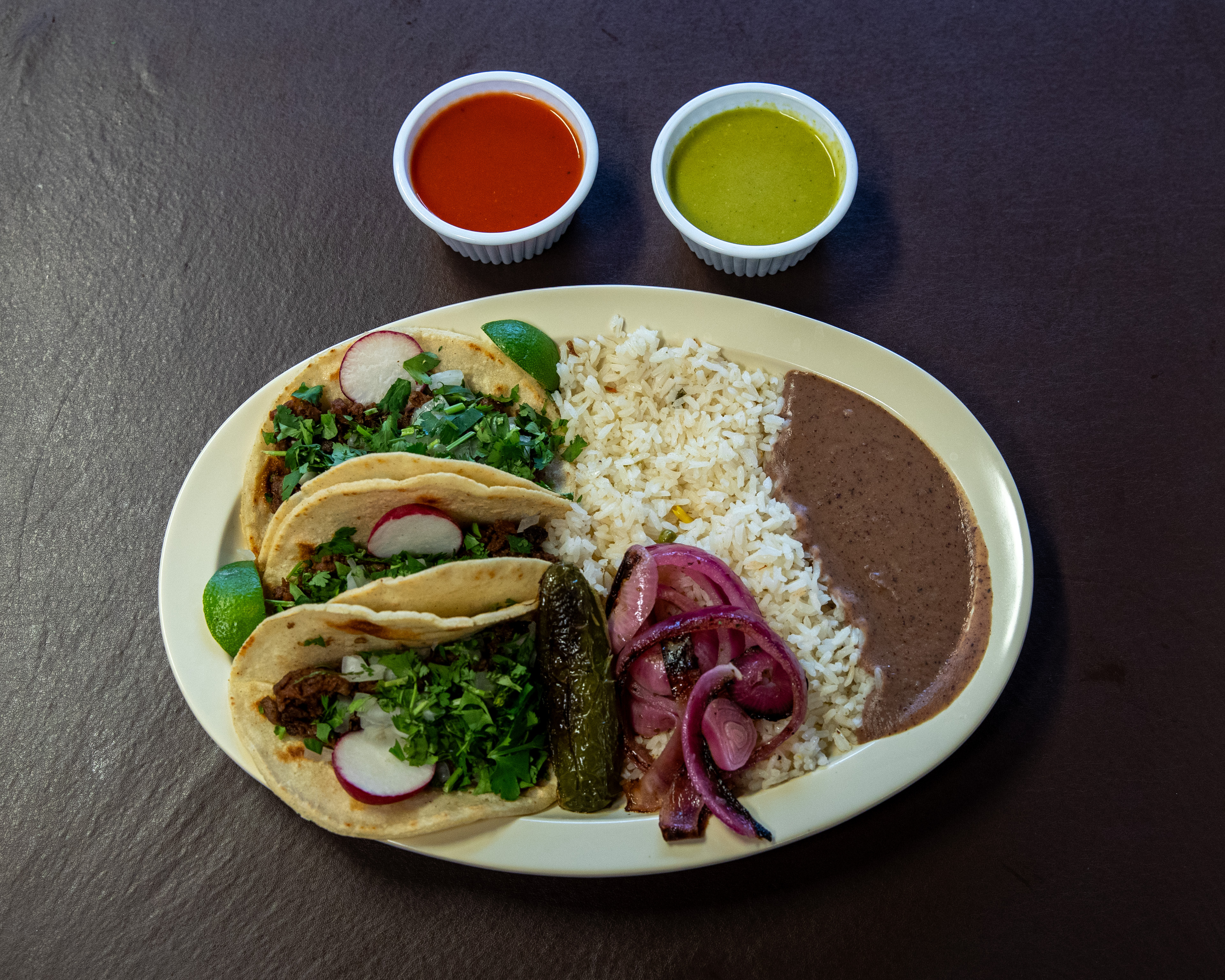 Three taco dinner with homemade tortillas, rice, beans, rice, jalapeño and onion for $14.99 at Pupuseria El Salvador in Wyoming on Thursday, Oct. 19, 2023. (Cory Morse | MLive.com)

