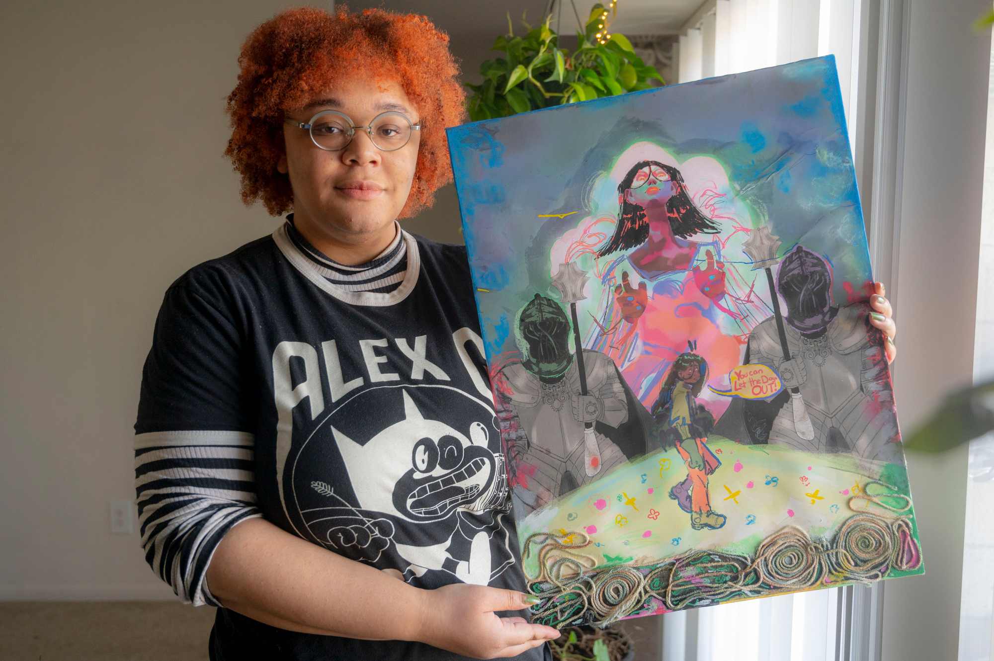 Cheyenne Fletcher poses with her mixed media artwork entitled "Forward Thinking” at her home in Ann Arbor on Wednesday, Feb. 8, 2023.
