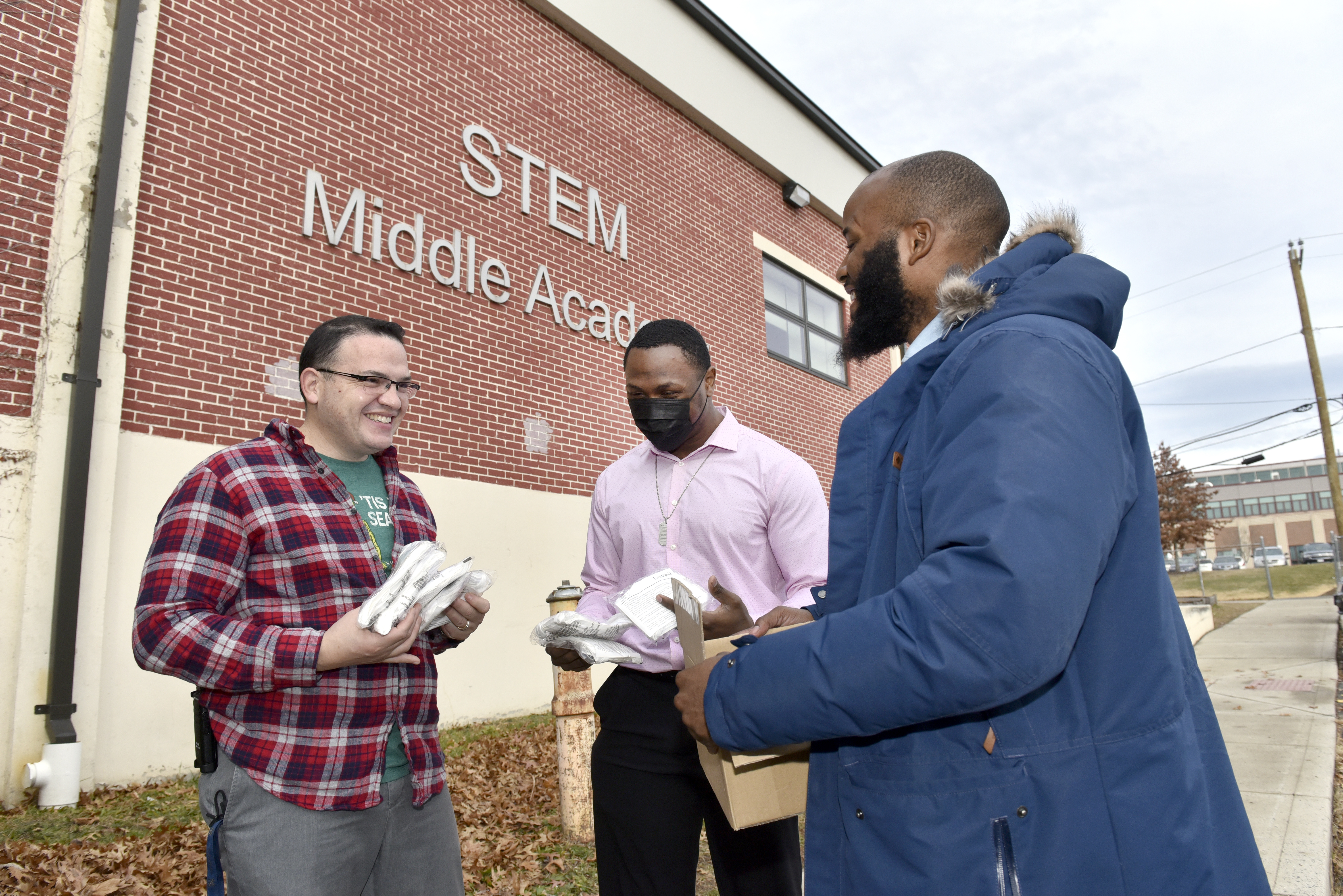 Kashawn Sanders (center),  president of the Follow My Steps Foundation, and foundation vice-president Tyrone Williams (right), brought hundreds of facemasks to principal Luis Martinez (left) at the Springfield STEM Middle Academy.   (Don Treeger / The Republican)  12/16/2021