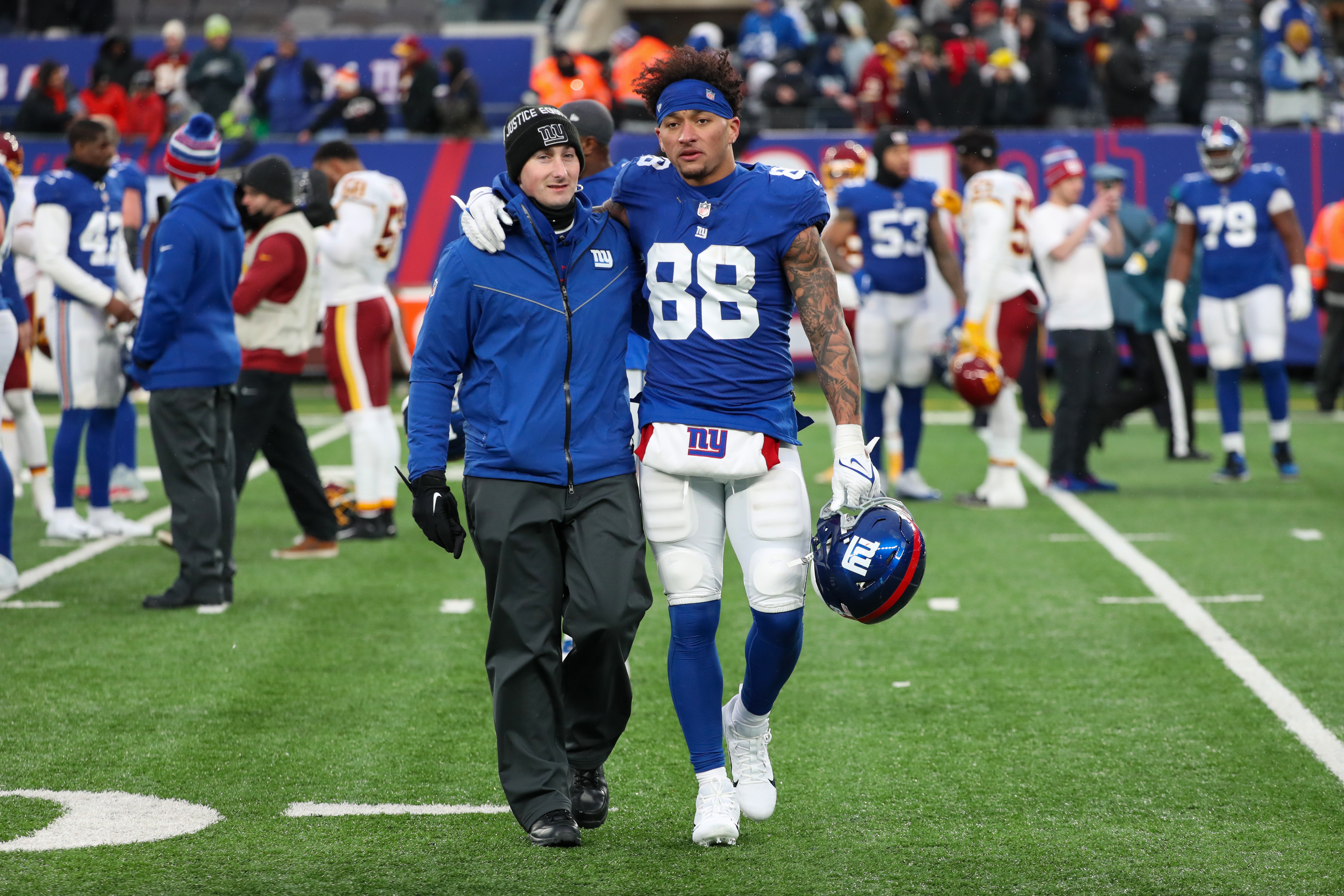 New York Giants assistant coach Derek Dooley and tight end Evan Engram (88) walk off after the Giants lost to the Washington Football Team, 22-7, on Sunday, Jan. 9, 2022 in East Rutherford, N.J.
