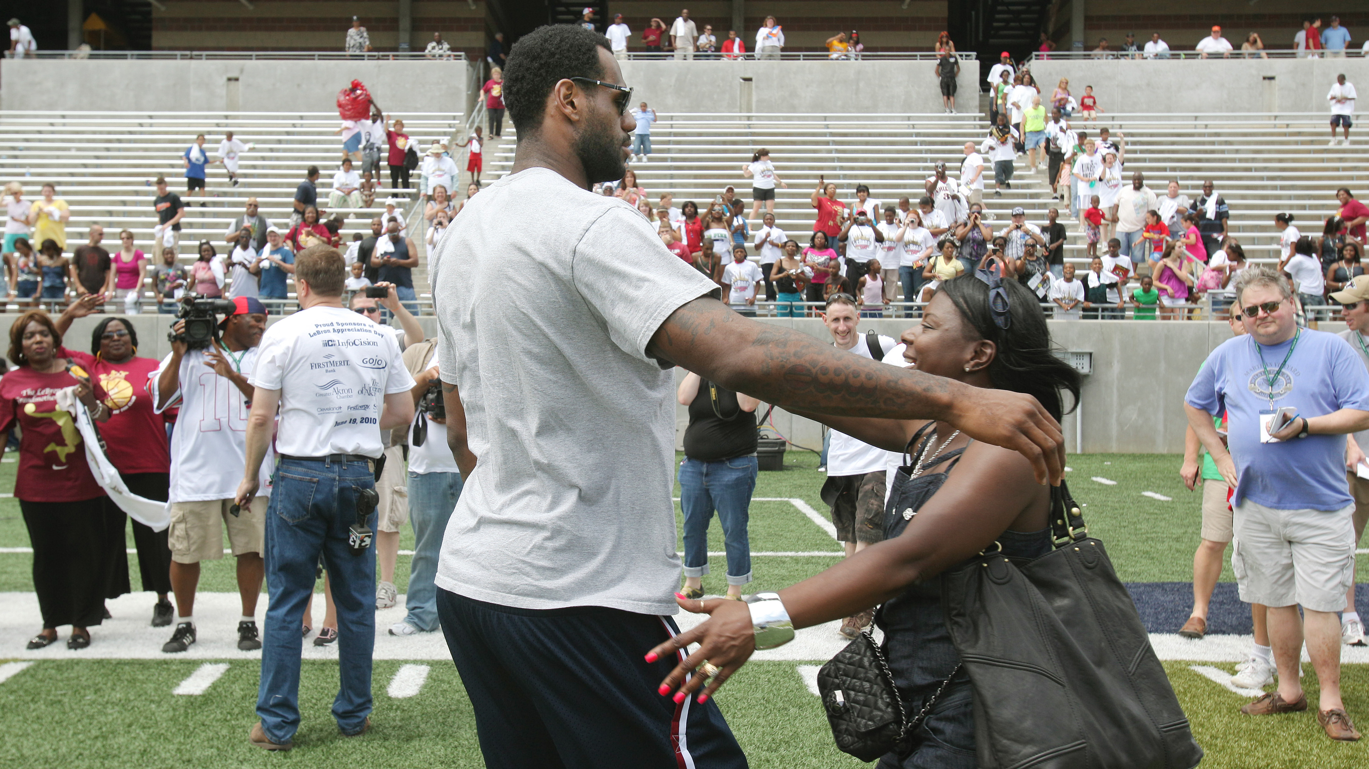 Cleveland Cavaliers LeBron James is hugged by an unidentified family friend in Akron University's InfoCision Stadium June 19, 2010 at the end of a LeBron James Appreciation Day rally where he was honored by receiving a crystal award for Akron's Hometown Hero.  Cavs fans were hoping to persuade James in staying with the Cavs during his free agency quest starting July 1, 2010.  (John Kuntz / The Plain Dealer) 