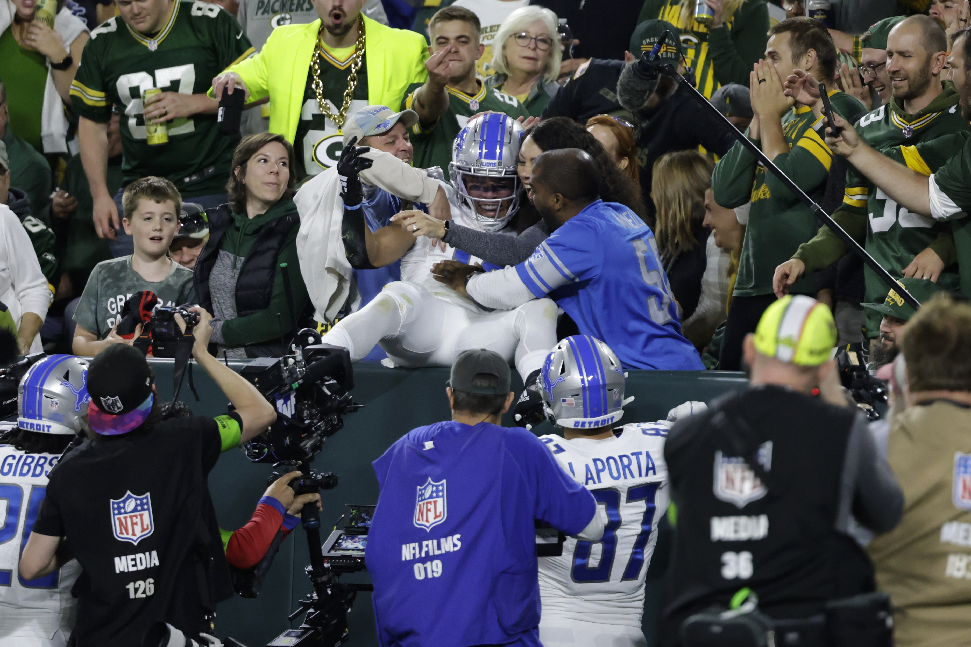 Packers fan dumps beer on Amon-Ra St. Brown after Lambeau Leap