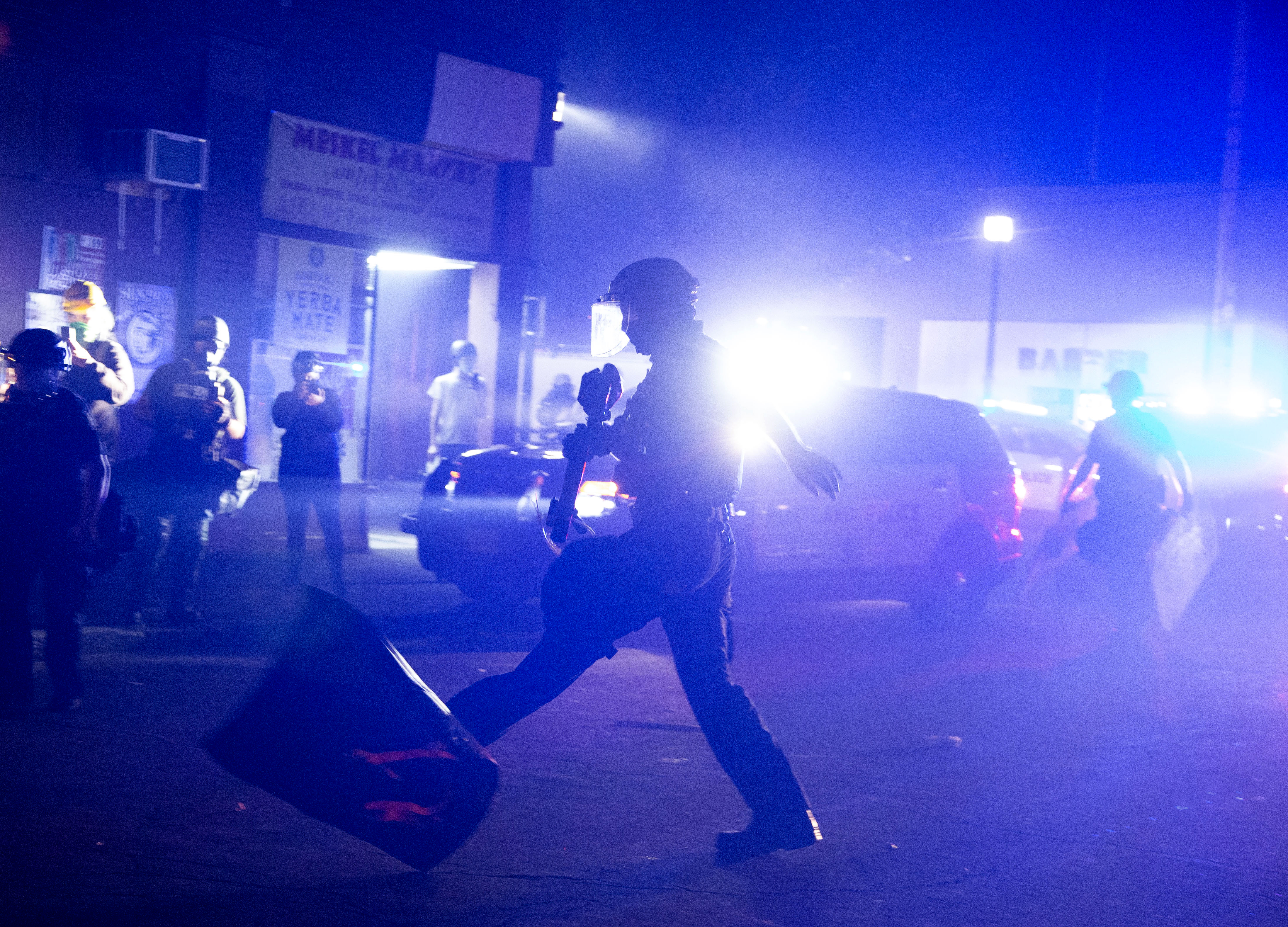 Portland Police respond to a few dumpsters on fire by pushing protesters away from the area in North Portland during what they called an unlawful assembly.  August 14, 2020 Beth Nakamura/Staff