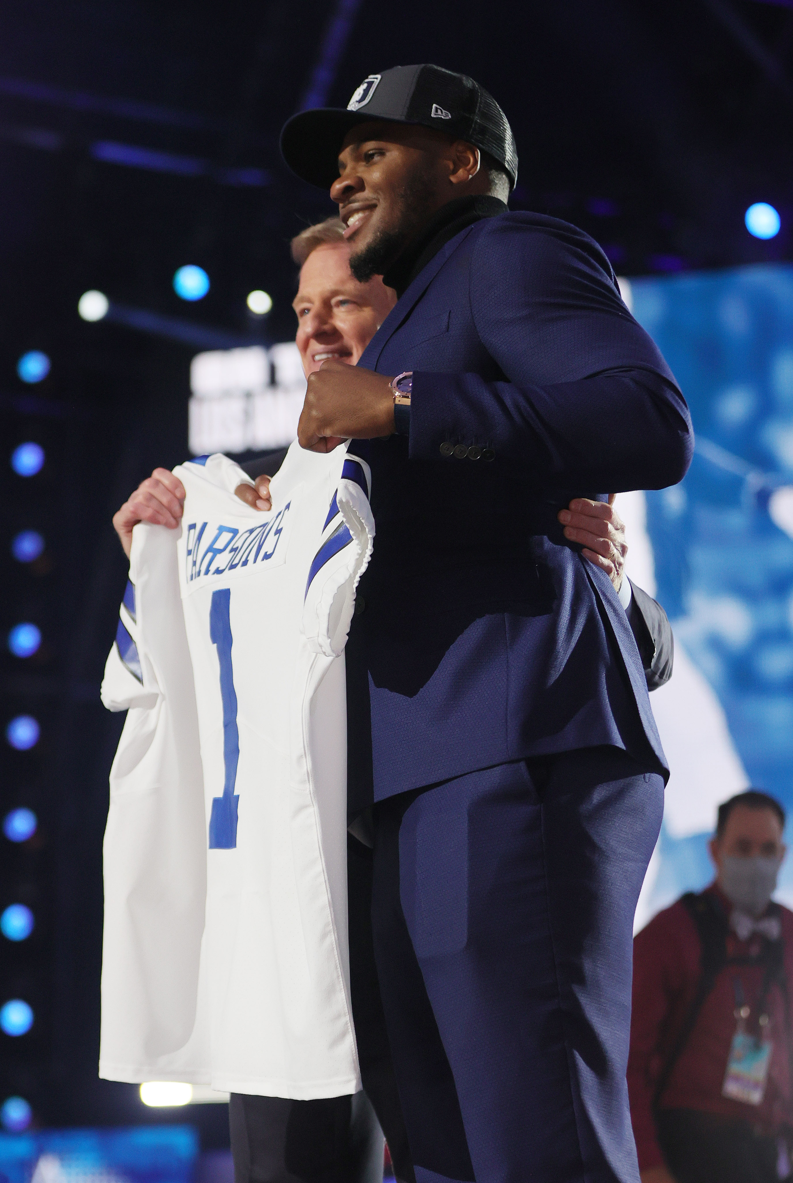 Penn State linebacker Micah Parsons, right, holds a team jersey with NFL  Commissioner Roger Goodell after the was chosen by the Dallas Cowboys with  the 12th pick in the NFL football draft