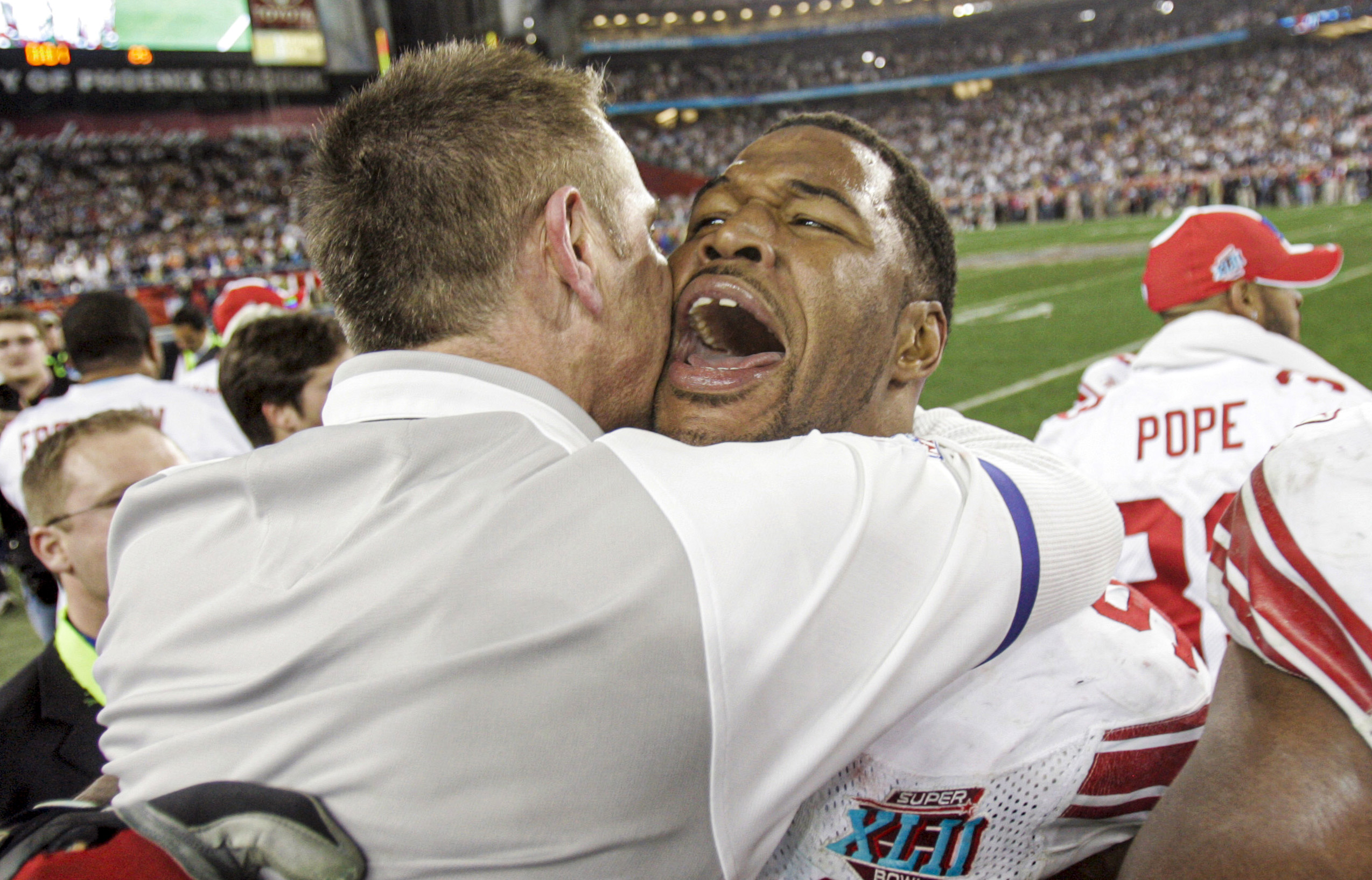 Giants DE Michael Strahan embraces defensive coordinator Steve Spagnuolo after  the New York Giants defeat the New England Patriots at University of Phoenix Stadium in Super Bowl XLII.  GLENDALE, AZ  (2008 file photo by Andrew Mills | The Star-Ledger)