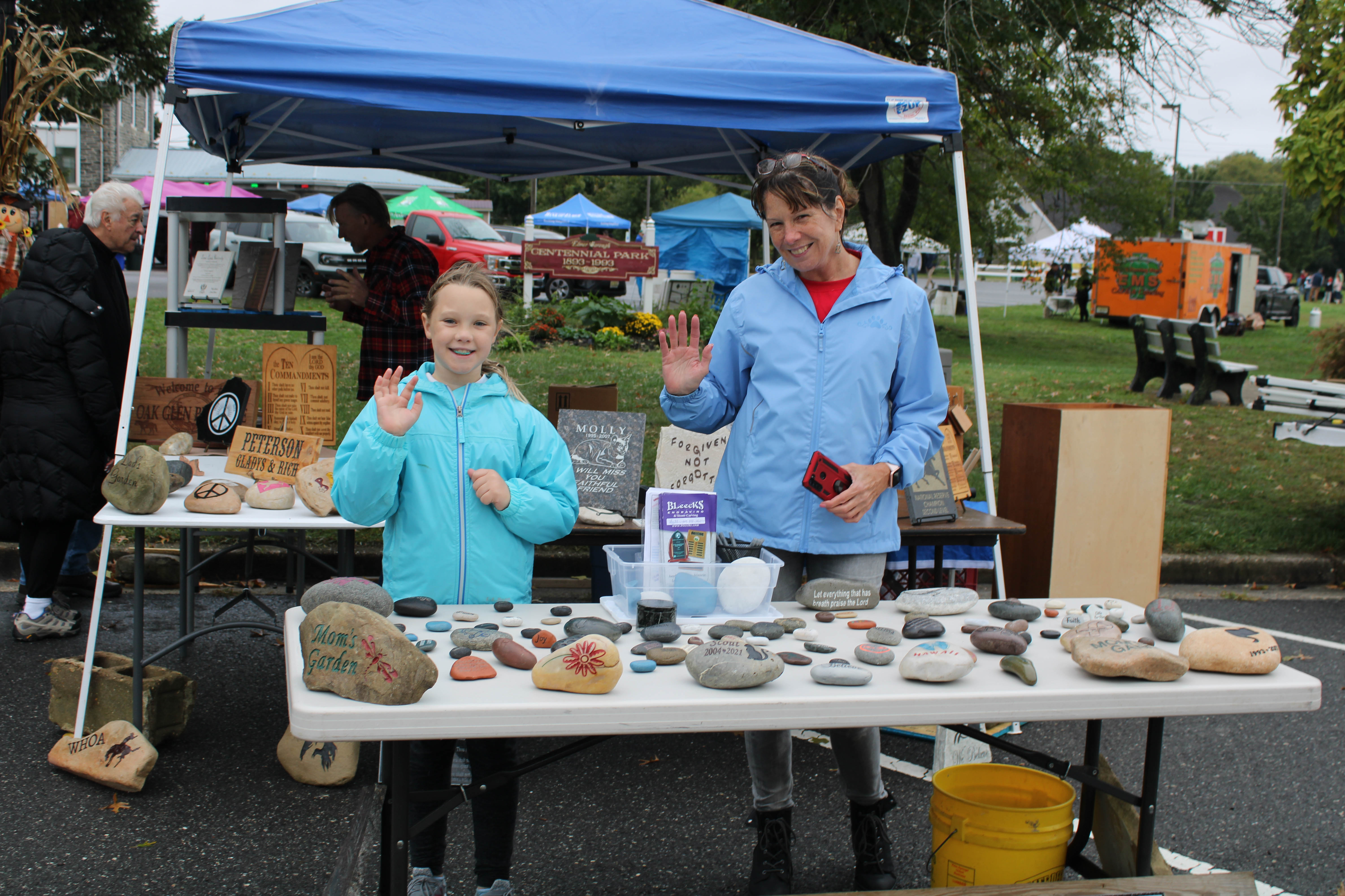Regina and Maci Bauman, 8, sell their custom home decorations at the Harvest Festival in Elmer, Saturday, Oct. 1, 2022.
