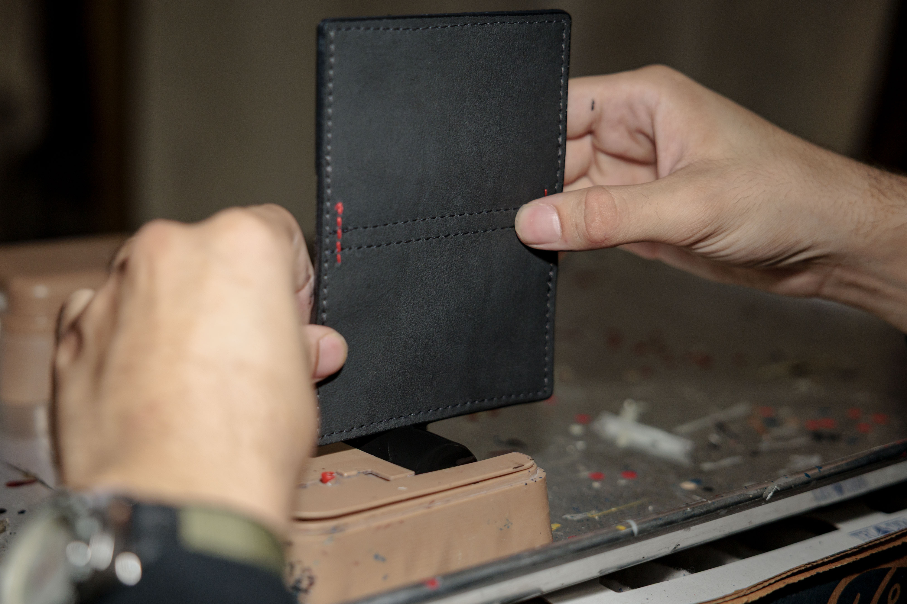 Eric Rranxburgaj applies edge paint to a bifold wallet at Pingree Detroit, 15707 Livernois in Detroit on Monday, Oct. 6 2025.