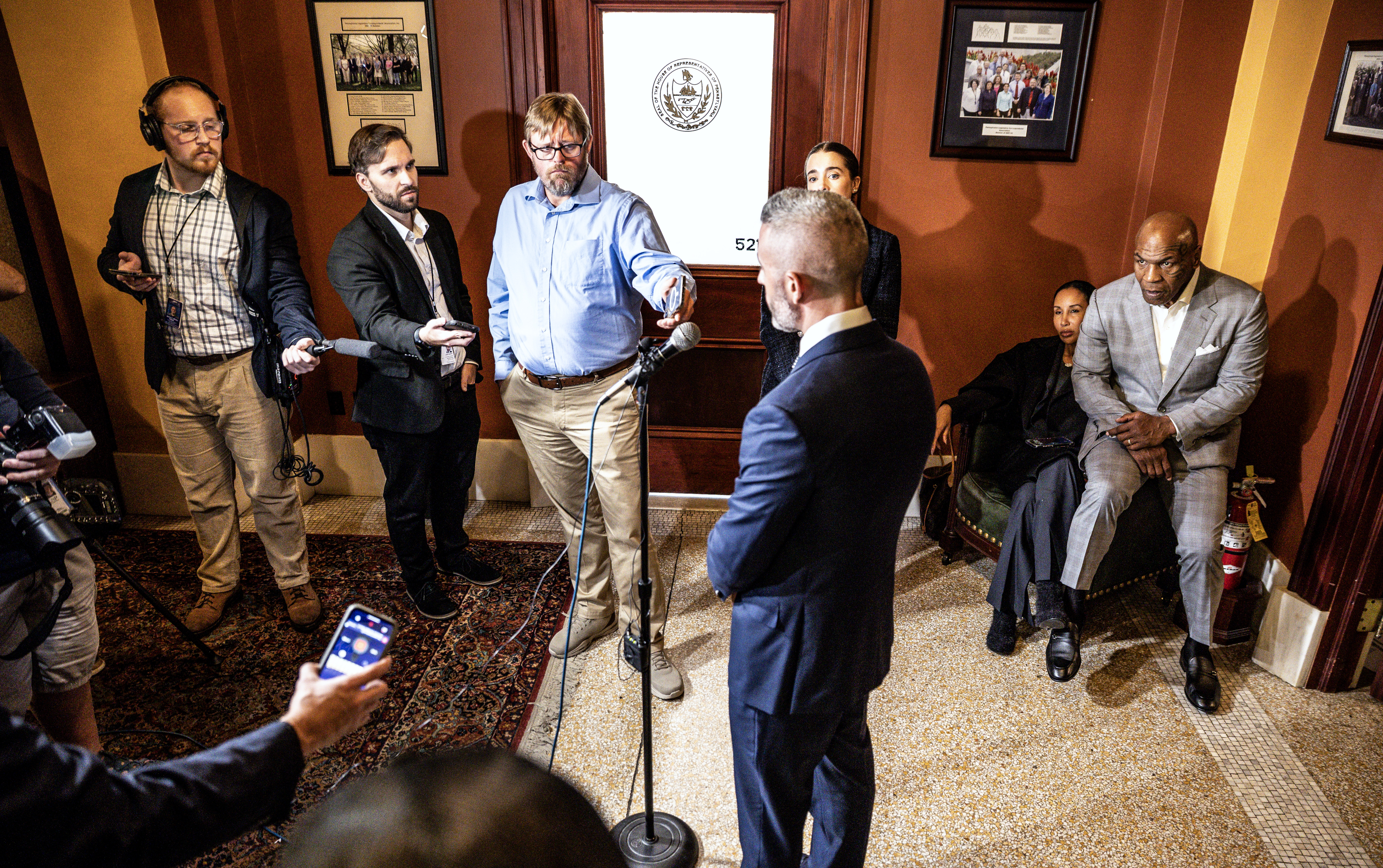 Mike Tyson, right, takes a break with his wife Lakiha Spicer, as Ryan Burke, COO of Carma HoldCo, speaks about meeting with state legislators at the Capitol in Harrisburg to advocate for the legalization of adult-use cannabis.   October 29, 2025.  Dan Gleiter | dgleiter@pennlive.com