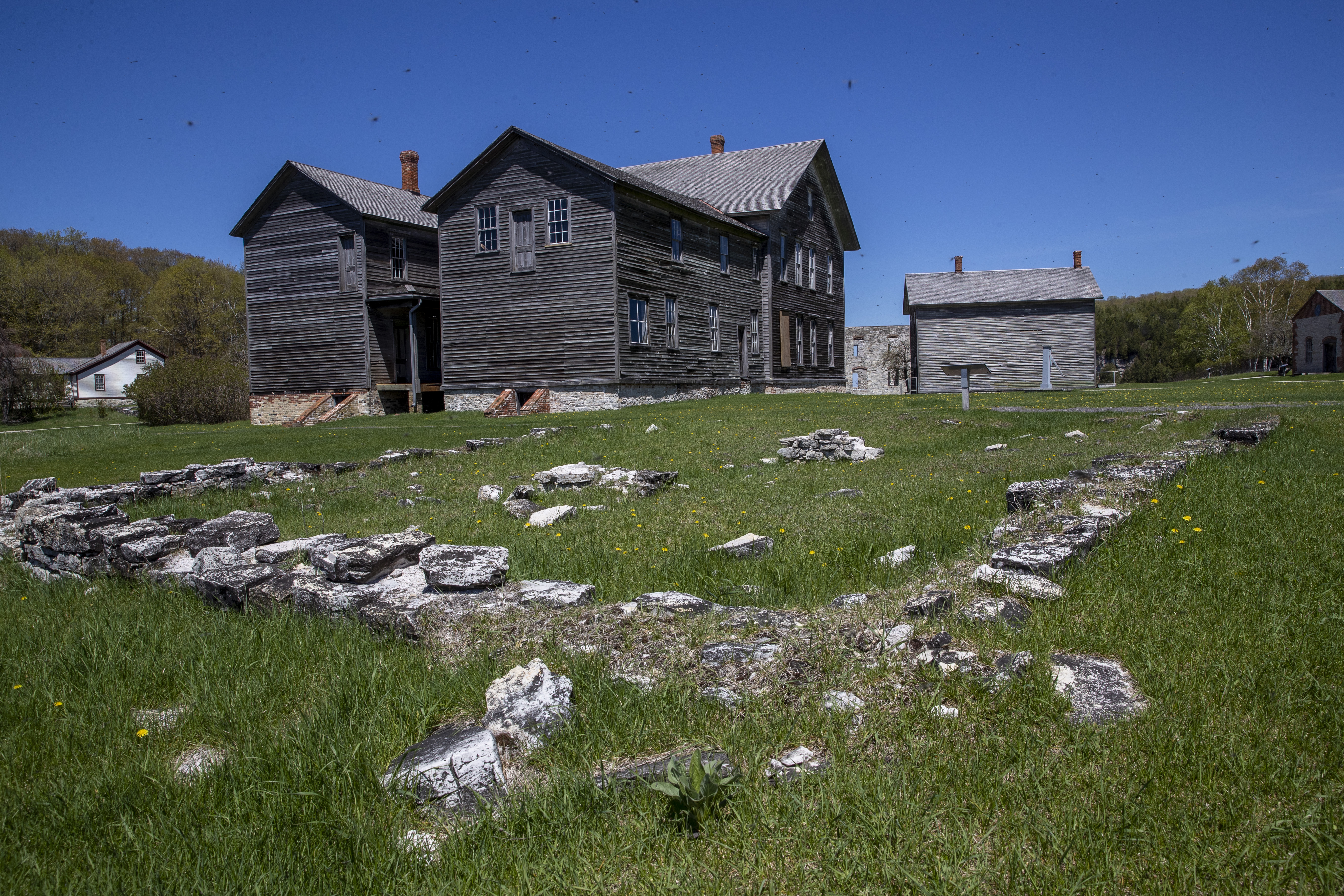 Bugs can be seen in the sky over historic townsite structures at Fayette Historic State Park near Garden on Tuesday, May 17, 2022. The historic townsite manufactured charcoal pig iron between 1867 and 1891. (Cory Morse | MLive.com)
