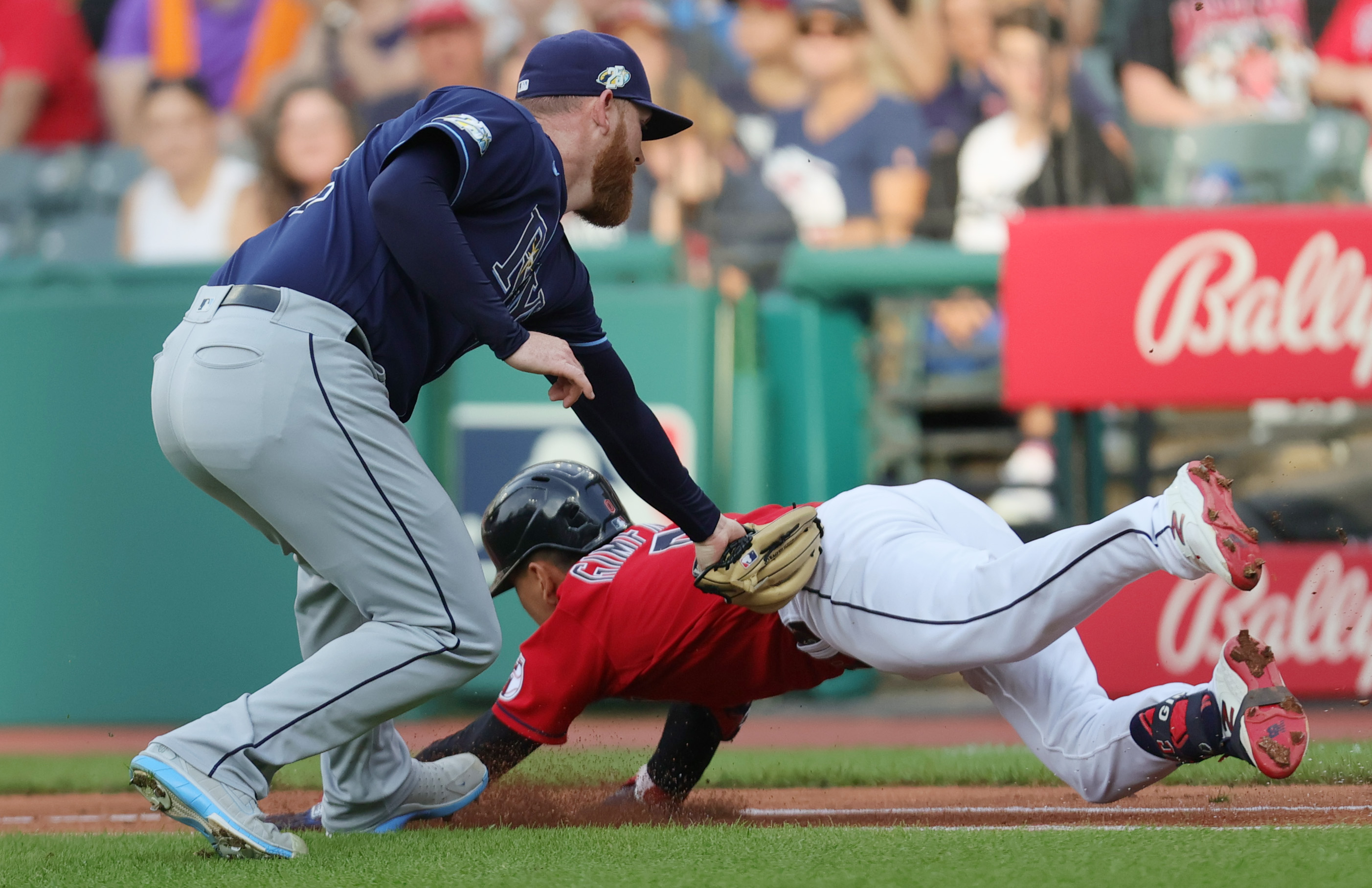 Cleveland Guardians second baseman Andres Gimenez dives for the first base bag as he is tagged out by Tampa Bay Rays starting pitcher Zack Littell