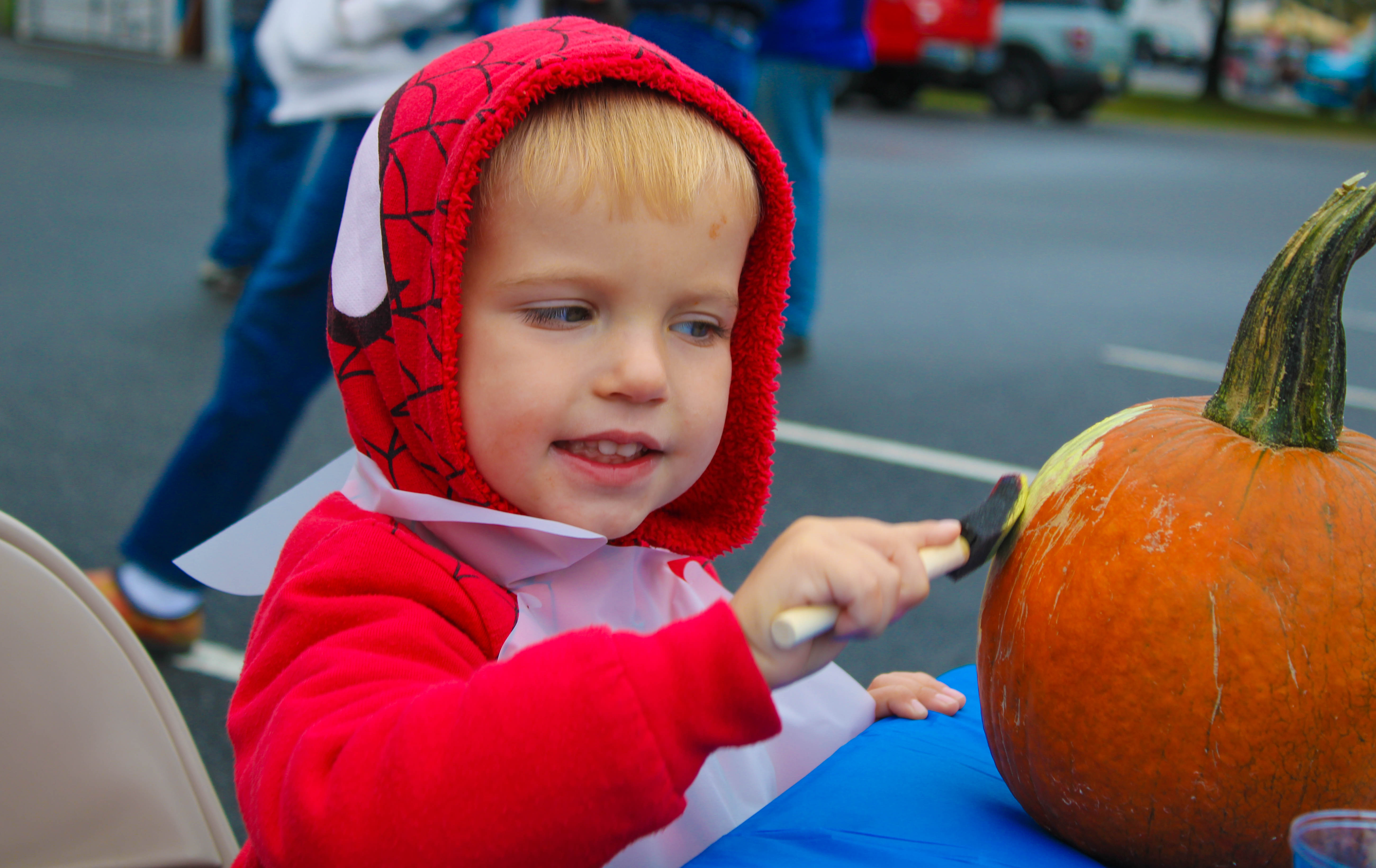 Nathan Jereasi, 3, paints a pumkin at the Harvest Day Festival in Elmer, Saturday, Oct. 1, 2022.