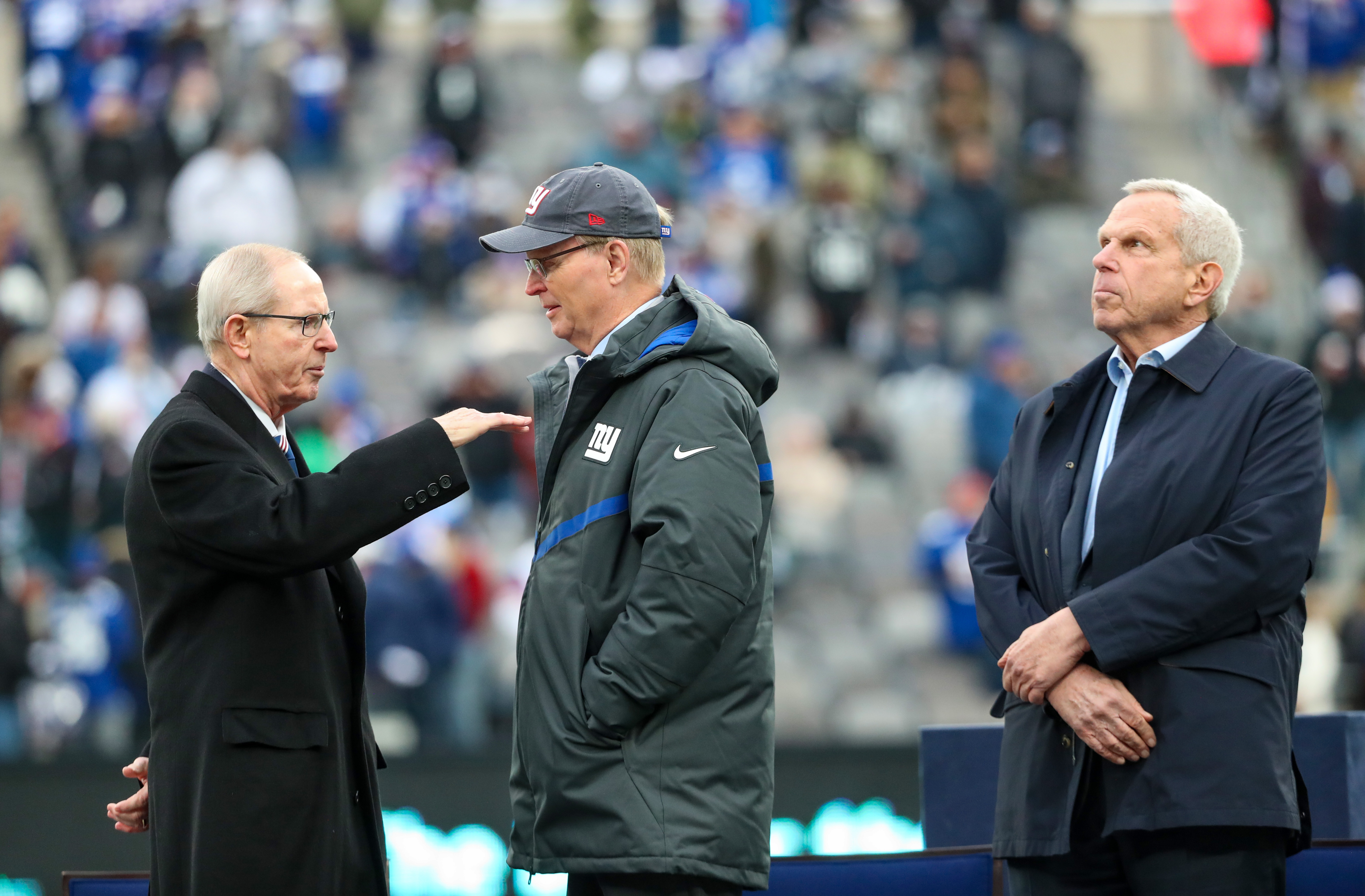 Former New York Giants head coach Tom Coughlin (left) speaks with Giants owners John Mara (center) and Steve Tisch during a halftime ceremony to honor hall of fame Michael Strahan on Sunday, Nov. 28, 2021 at MetLife Stadium.