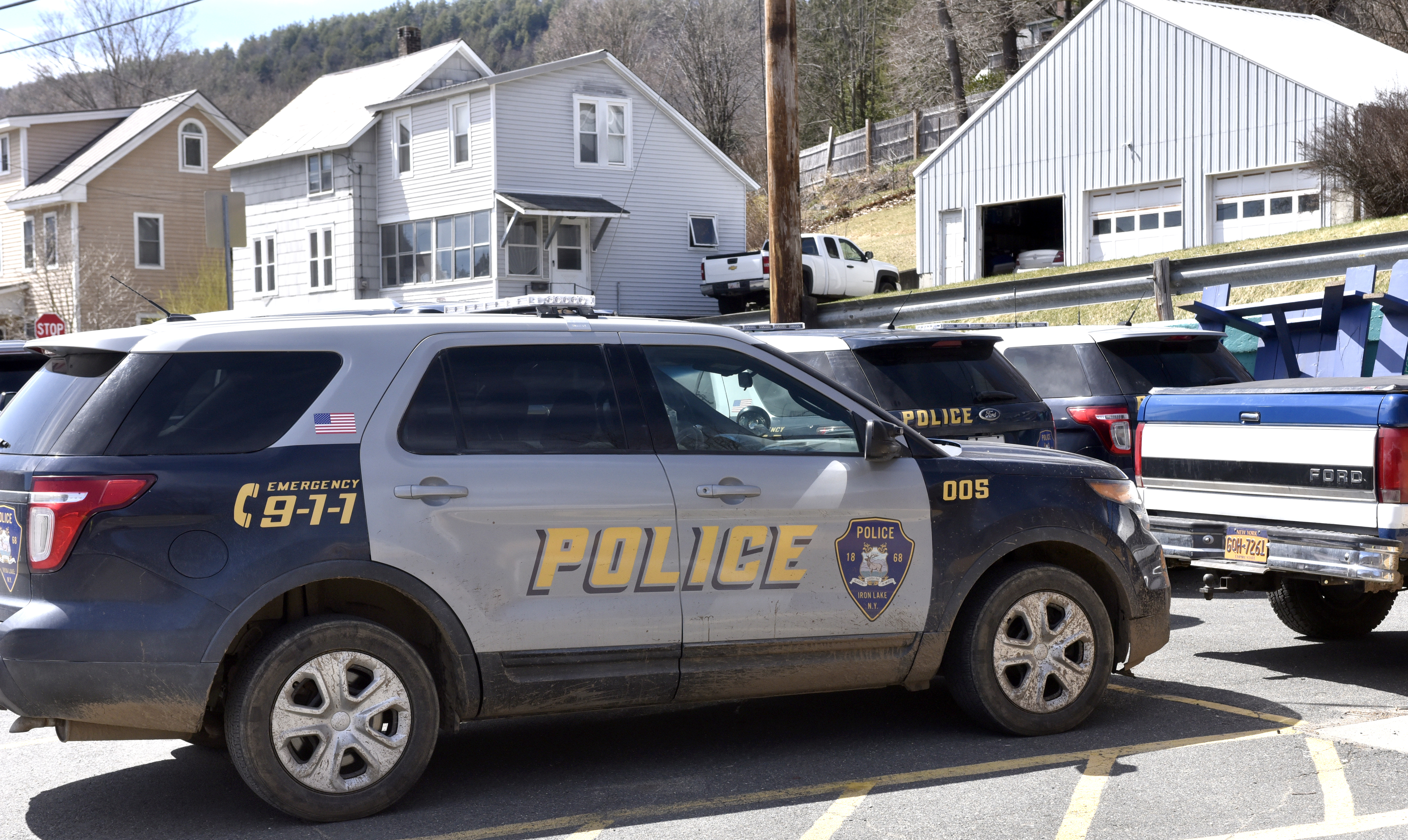 Vehicles from the fictional town of Iron Lake, New York sit in a lot on State Street in Shelburne Falls. The cars are being used in the series Dexter, now filming in downtown Shelburne Falls, April 7, 2021.   (Don Treeger / The Republican)