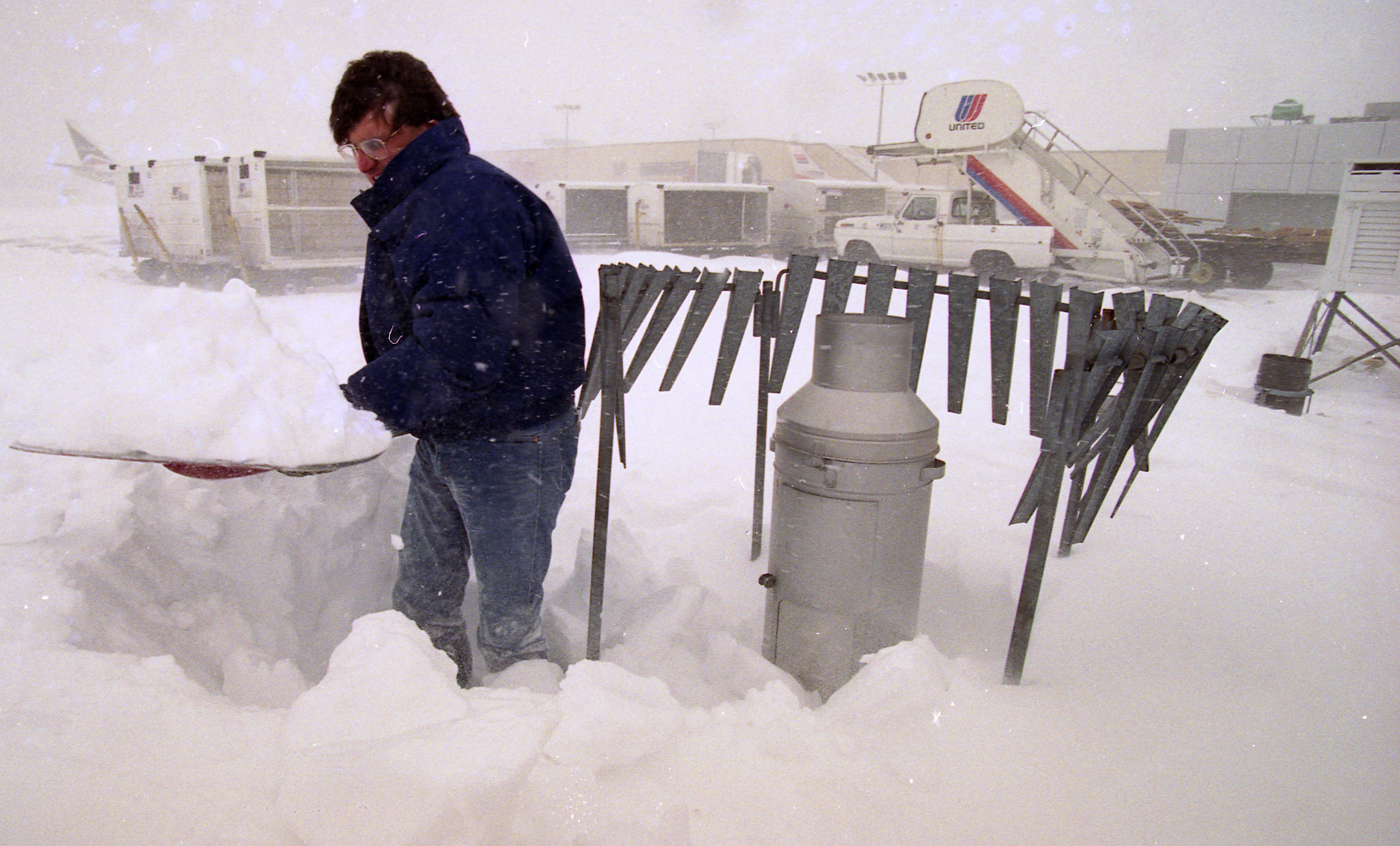 Jon Elardo, a meteorologist with the National Weather Service at Hancock Airport, shoveling out snow during 2 day storm so he can take readings.