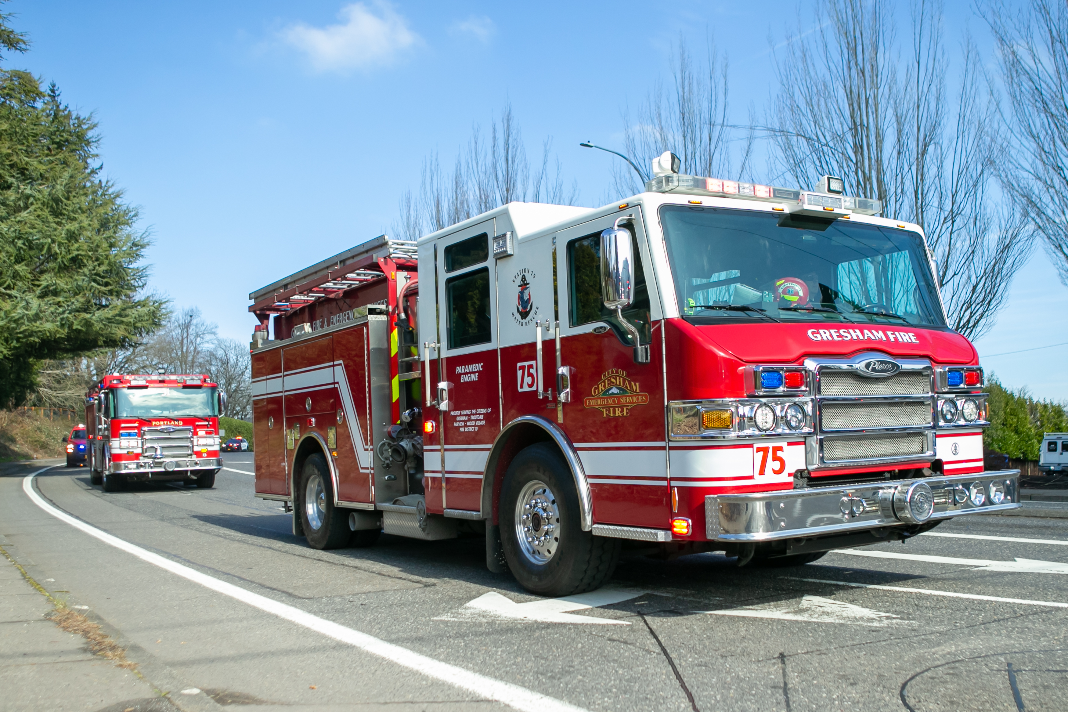 A procession of first responders drives through downtown Gresham, Oregon honoring Gresham Firefighter Brandon Norbury on Wednesday, Feb. 15 2023.