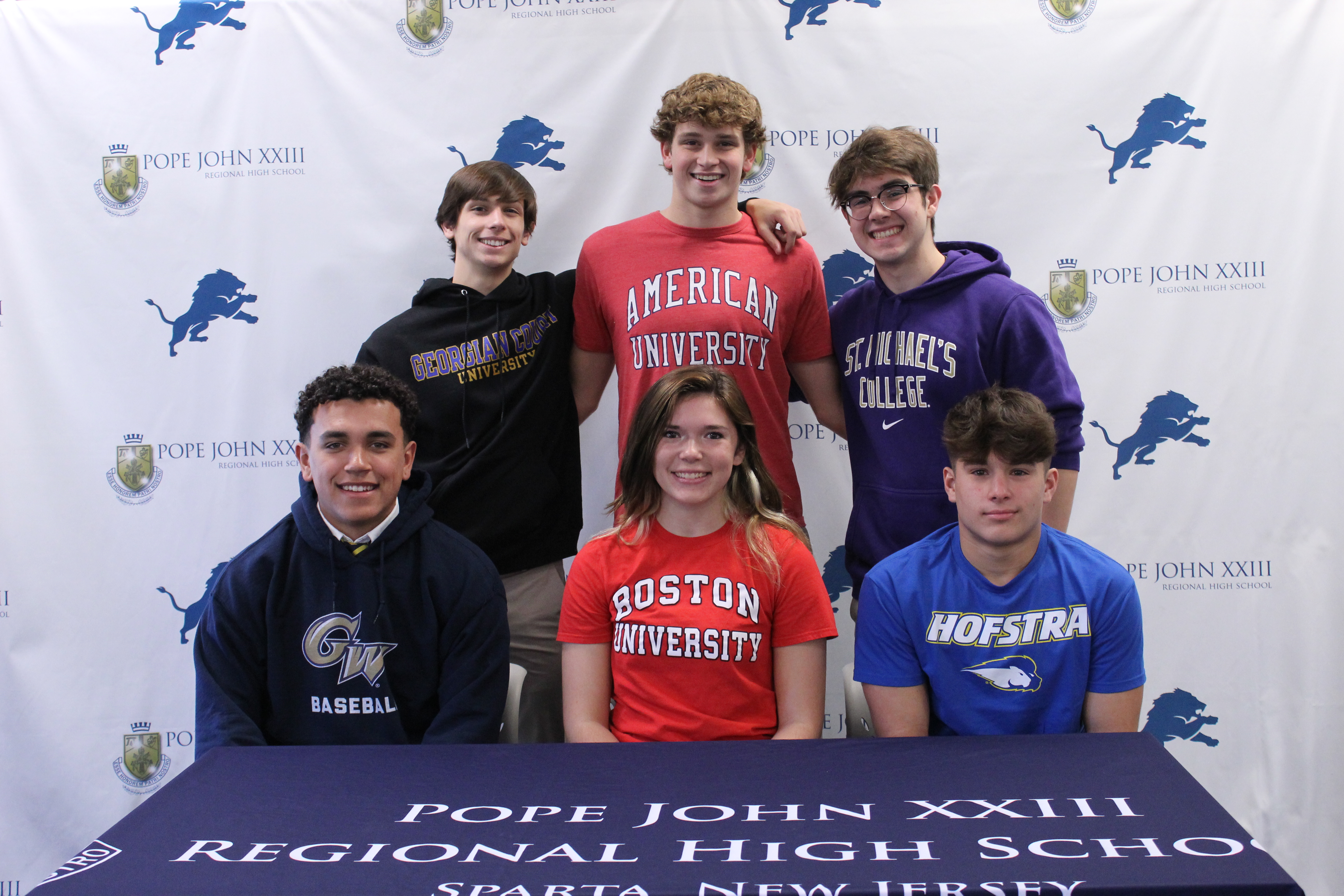 Pope John Signees show their commitments. Front Left to Right, Ayden Alexander, Carly Sarisky, and Jack Sakowski. Back Left to Right, Joseph Barnish, Henry Bysshe, and Jonathan Kane.