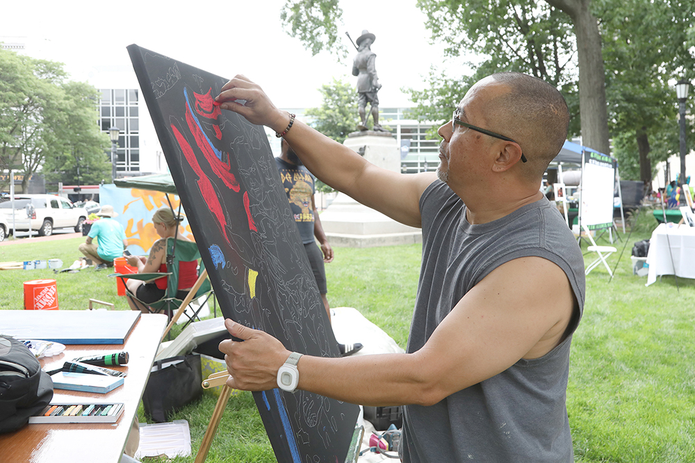 Artist Frankie Borrero works in his drawing at Chalk for Change 2022 taking place at Court Square in Springfield on July 16th. (Ed Cohen Photo)