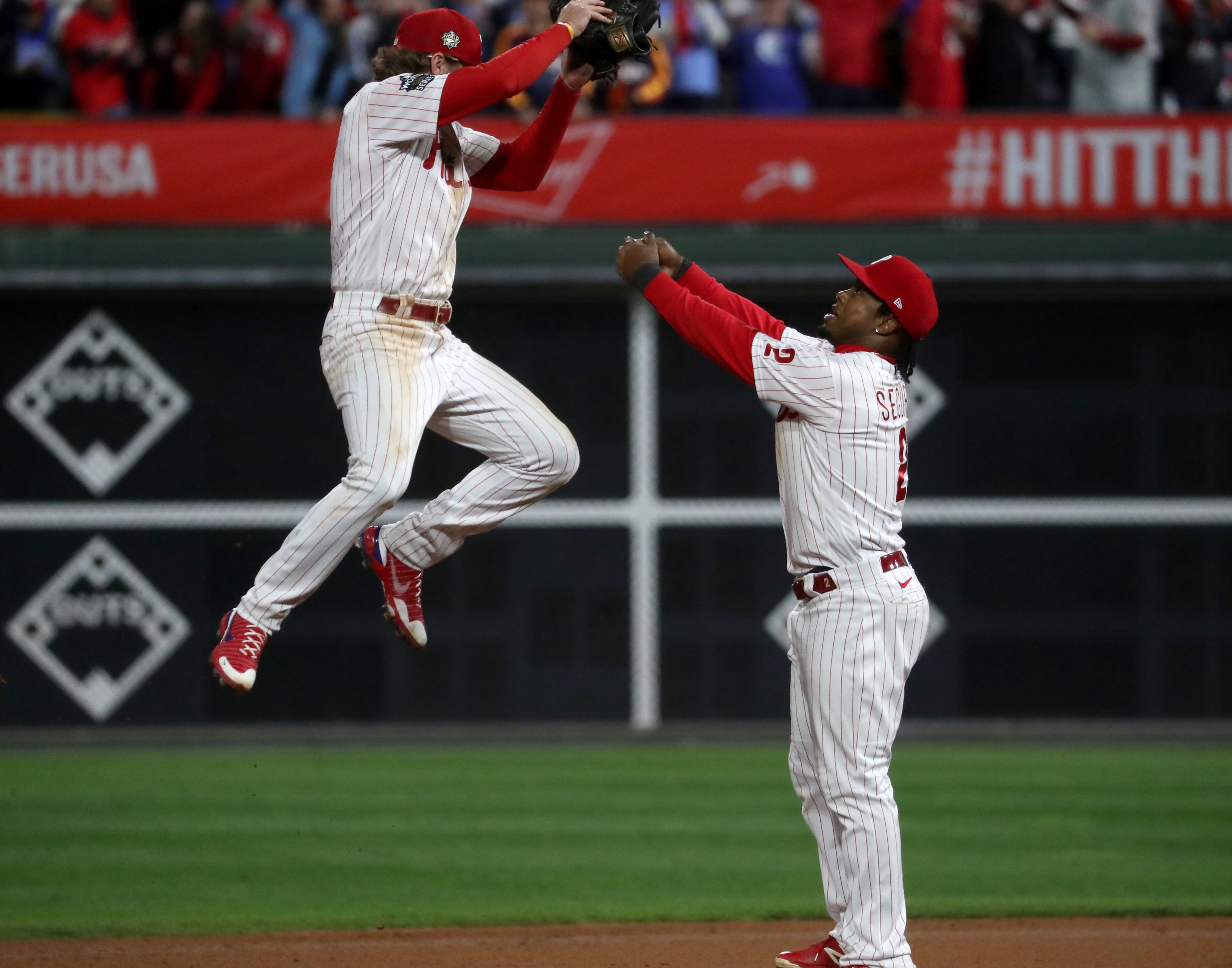 Bryson Stott (5) and Jean Segura (2) of the Philadelphia Phillies celebrate a 7-0 win during World Series Game 3 against the Houston Astros at Citizens Bank Park, Tuesday, Nov. 1, 2022.