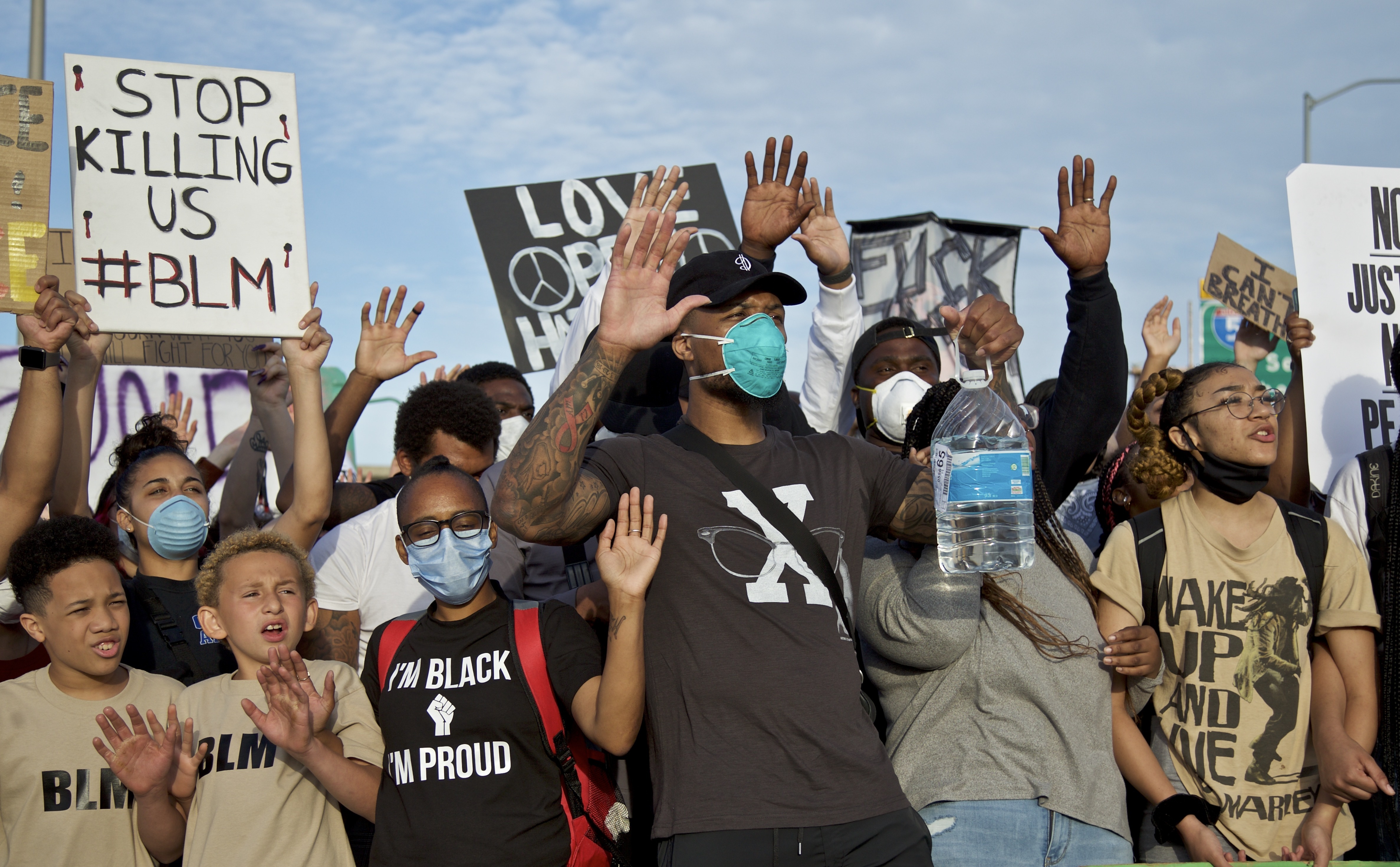 Portland Trail Blazers' Damian Lillard, center, joins other demonstrators in Portland, Ore., during a protest against police brutality and racism, sparked by the death of George Floyd, who died May 25 after being restrained by police in Minneapolis. (AP Photo/Craig Mitchelldyer)